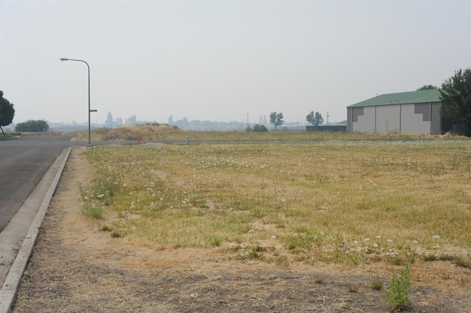 Large corner lot nearly 1 acre in size (.84+/-ac). Zoned light industrial, conveniently located in industrial park near the airport. Utilities at the property line. Possible owner terms.