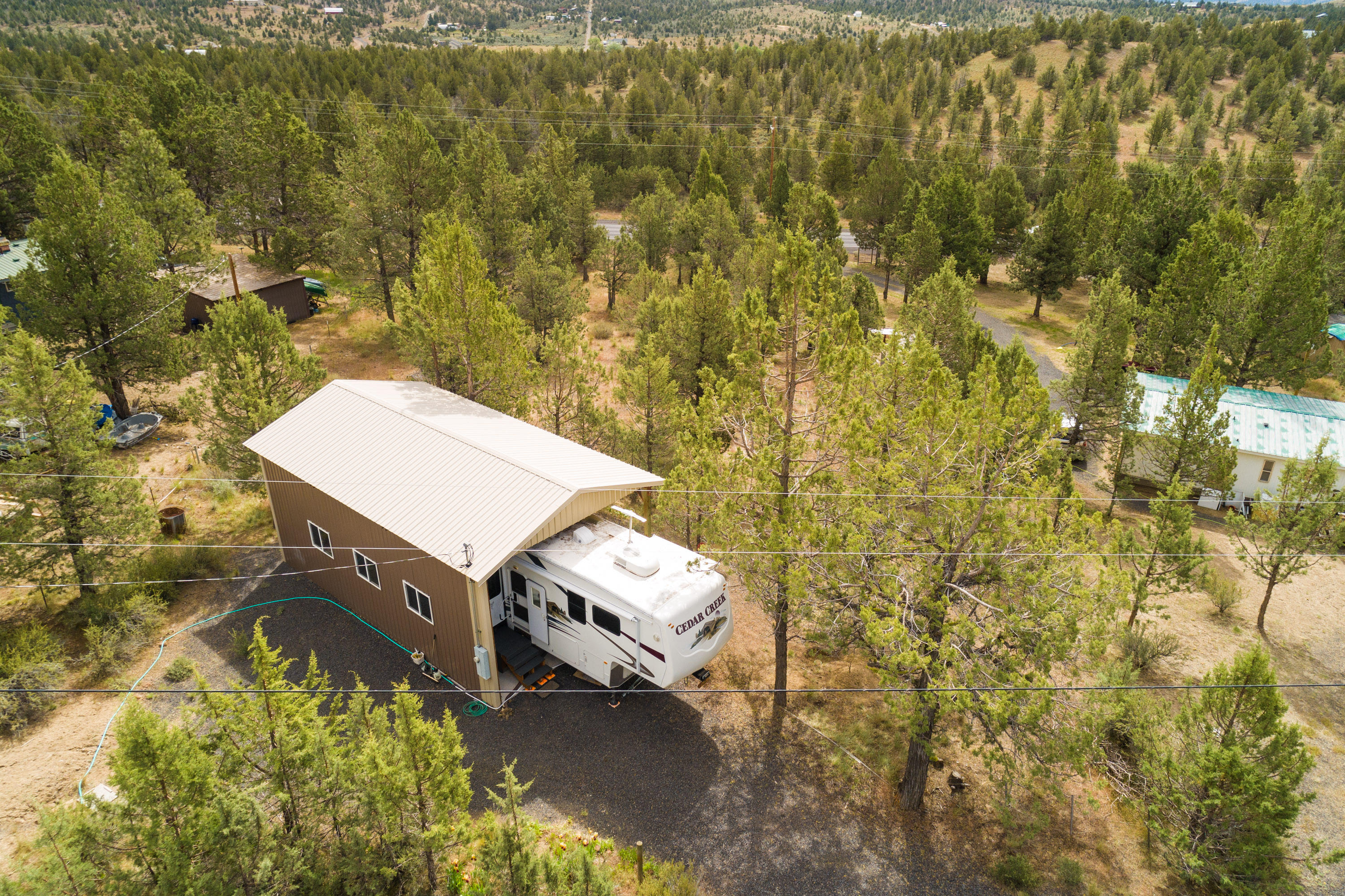 Recreational property with RV cover/pad, septic, water and 200amp power within a couple miles of Prineville Reservoir. Watch the included video for a drone flyover of the property and the adjoining BLM. Just down the paved road to the west is public access to BLM that allows miles of uninterrupted access to trails, recreation, hunting and solitude. The community water is $50 per month and is unmetered. The steel roofed and sided RV cover is a pole construction 36'x20' and is enclosed on two sides.  It could be fully enclosed with a roll up door without much added expense.  It also has a lockable storage area that is fully enclosed as well.  The property is fully fenced and has good juniper cover for privacy.  You can use the lot for a recreational launch pad or as a homesite with all the needed infrastructure already in place!