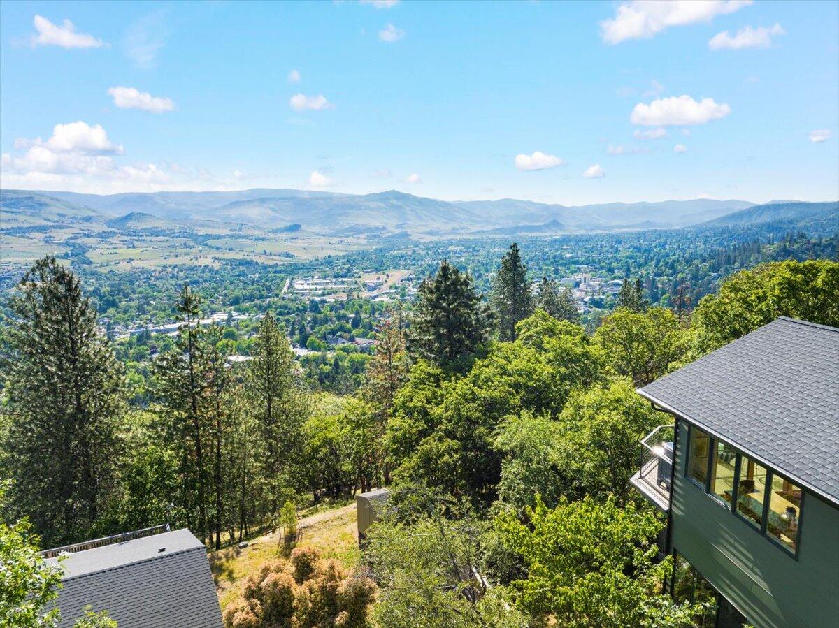 One of the best views in Ashland! Upscale 2019 Asher built 270 ° view home was built on a ridge top above Ashland's Plaza abutting Strawberry Hald Park & trail system. Light from abundance of windows & white oak floors create a light & airy interior. Open contemporary spaces, stunning kitchen with walnut cabinets, large Quartzite island & Jenn-Aire gas range with griddle. Gather at the 10' banquette for dining & to enjoy the city lights & forever view. 14' wooden Sierra Pacific glass doors lead to the expansive view decking. Sunrise views of the Cascade Range infuse the main level primary suite with luxury bath - heated floors, soaking tub, tiled walk-in shower plus large walk-in closet. Lower level has 9 foot ceiling, 2 additional bedrooms, family room, wine cellar & full bath. Office with separate entrance with built in shelving & desk. Large storage area. Fire sprinklered throughout, electric car charger, RV parking with water & electric. No HOA CCR's. Rated GOLD by Earth Advantage