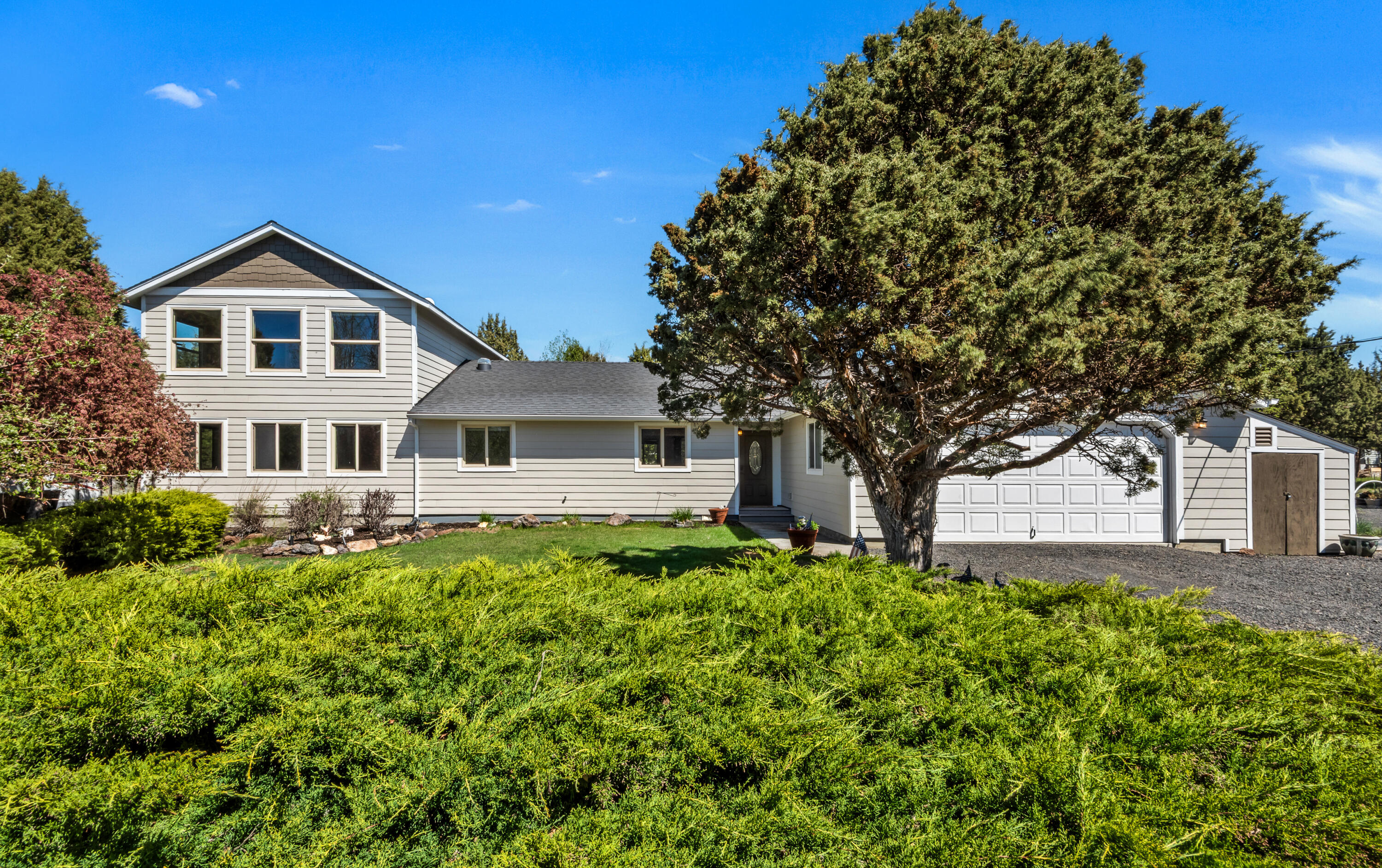 Situated on 2.51 acres, this 3-bed, 3-bath residence offers a peaceful setting and a versatile floor plan.  This 2336 sq ft home features two primary bedrooms suites, new siding and windows throughout. Great separation throughout the home makes it perfect for guests or multi generational living. Large main level bonus room that can easily serve as theater, or game room. Outdoor living is a highlight, with a spacious deck, gazebo, and water feature that create an inviting atmosphere. A separate 48' x 36' shop offers ample space for projects, storage, or hobbies, with plenty of room for tools, equipment, or additional vehicles. The fully fenced property includes mature landscaping, greenhouse, chicken coop, and covered RV parking with ample storage. Private gated entry that offers both security and a sense of arrival. Move in ready- with a quiet and serene setting that should appeal to many. Make your appointment today.