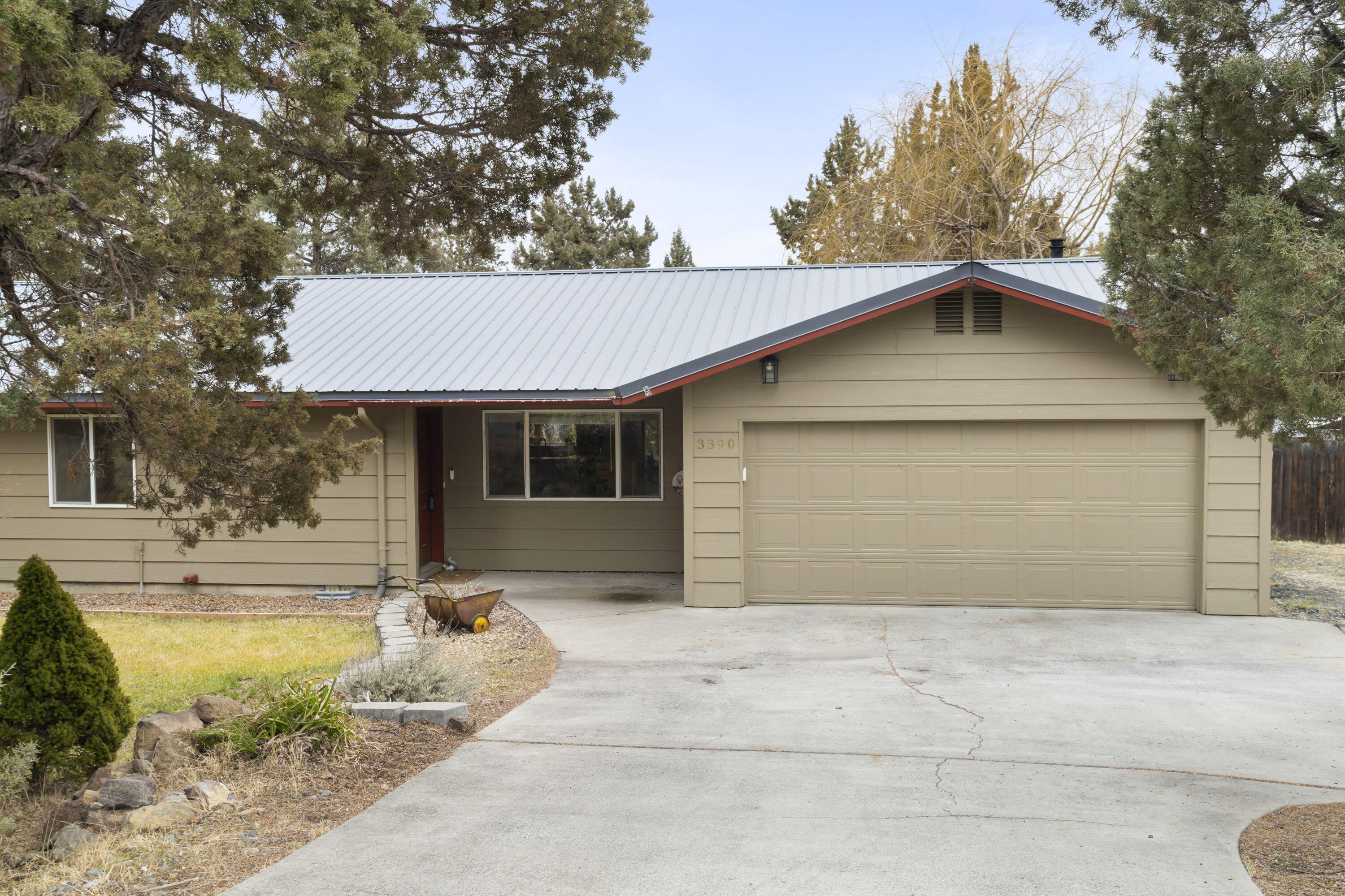 This tastefully updated home offers privacy and convenience on a spacious half-acre lot, just minutes from town with quick Hwy 97 access. The spacious, fully fenced backyard is amazing, featuring a covered deck, dog run, hot tub, and lush landscaping with mature fruit trees, hops and flowers. A charming, insulated garden shed/workshop with heat and electricity provides the perfect space for hobbies or storage. RV parking includes power and sewer hookup for added convenience. The remodeled kitchen features knotty maple soft-close cabinetry, granite counters, and a stylish backsplash. The great room features a cozy wood-burning fireplace, maple hardwood floors, and abundant natural light. Updated bathrooms add modern comfort, while a durable metal roof, installed in 2017, ensures peace of mind. Multiple outdoor spaces make this home ideal for entertaining or relaxing. Don't miss this rare opportunity to own a beautiful slice of Redmond!