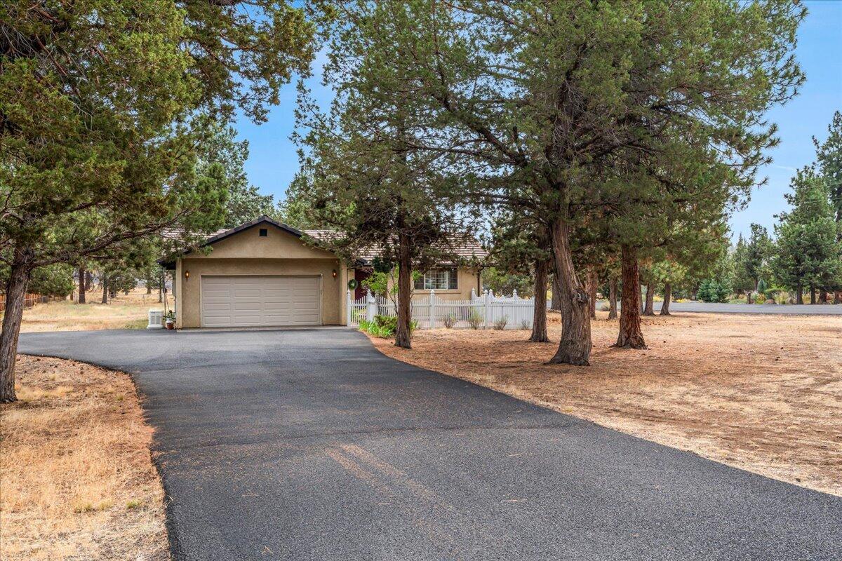 With room for your RV, boat, and all your Central Oregon gear, this corner-lot home offers both comfort and adventure-ready space. Located in the quiet community of Wychus Canyon Estates, this single-level 3-bedroom, 2-bathroom home sits on just under an acre and features low-maintenance stucco siding, a tile roof, an enclosed front courtyard, and an enclosed rear courtyard/patio for private outdoor living. Inside, enjoy vaulted ceilings, new skylights, new carpet, and newer appliances in a light-filled layout. A newer whole-house generator adds peace of mind. Recent updates include tree removal and a new asphalt driveway. The partially fenced yard and outdoor storage add function and convenience. This well-cared-for home is solid, spacious and ready for you to enjoy the Central Oregon lifestyle.