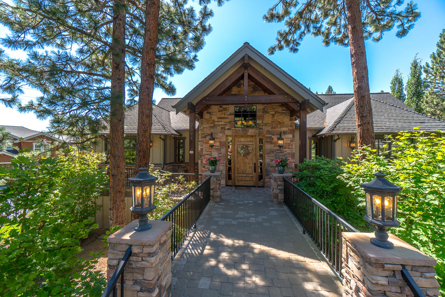 The PacNW comes alive in this striking lodge style home showing accents of wood and stone. Highlighted by exposed hand crafted timber trusses, the vaulted great room is lighted by a wall of windows illuminating the entertainer's kitchen with chiseled edge granite island counter. A stacked stone fireplace compliments the open yet warm ambiance of the living space. A spa-like retreat awaits in the owner's suite. Large and luxurious with a double sided fireplace from bedroom to effervescent air tub. Enjoy his & hers walk in closets, spacious walk in travertine shower, double vanities and heated floors for cold winter mornings. Downstairs you'll find a flex space for a home office or guest suite with its own patio. Bring your cars, boat, and all your Central Oregon hobbies as the 6 car garage will provide all your storage needs. Outside, enjoy numerous living spaces including a pavered patio with brand new grill and a wrap-around deck which is engineered, wired and ready for your hot tub!