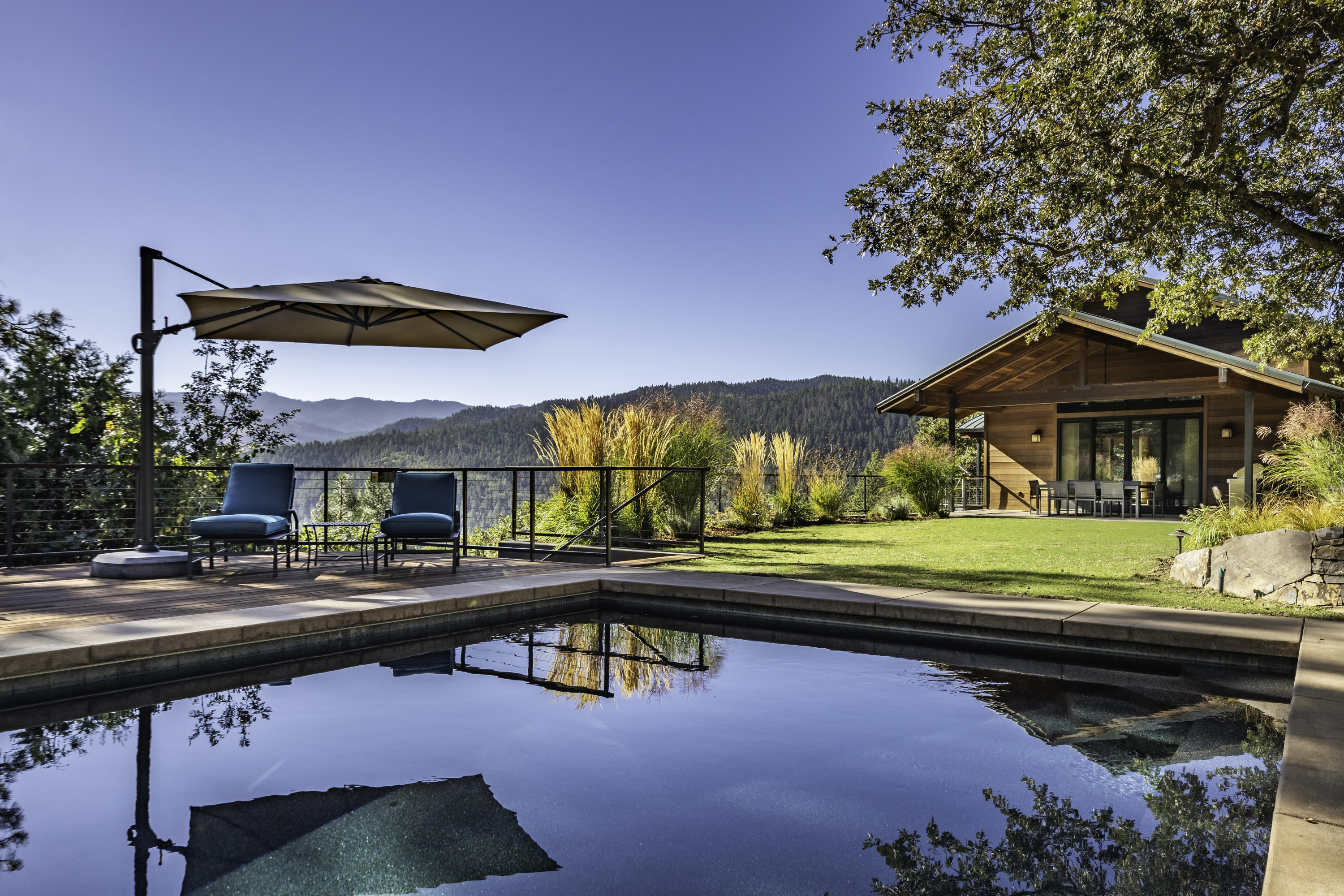One-of-a-kind secluded family compound with resort-quality construction, thoughtfully designed by an award-winning local architect. The fully-surveyed 100+ acre property features three separate finished living areas including a tri-level main home, guest house, and a detached office ''duplex'' — all with fire-resistant reclaimed old-growth redwood siding and metal roofing. Unparalleled panoramic views of surrounding peaks and undeveloped government land from four unique redwood decks. High-end finishes throughout must be experienced in person! The grounds include a gorgeous heated Pebble Tec pool with remote-controlled safety cover, extensive dry-stack artisan rock terracing, circulating pond with waterfall, raised garden beds, fruit trees, and lavender fields. Outbuildings include a detached garage shop, tool shed, well house, as well as an additional 20x24 building pad approved for a 2-story structure. Inquire with agents for access to complete details and maps.