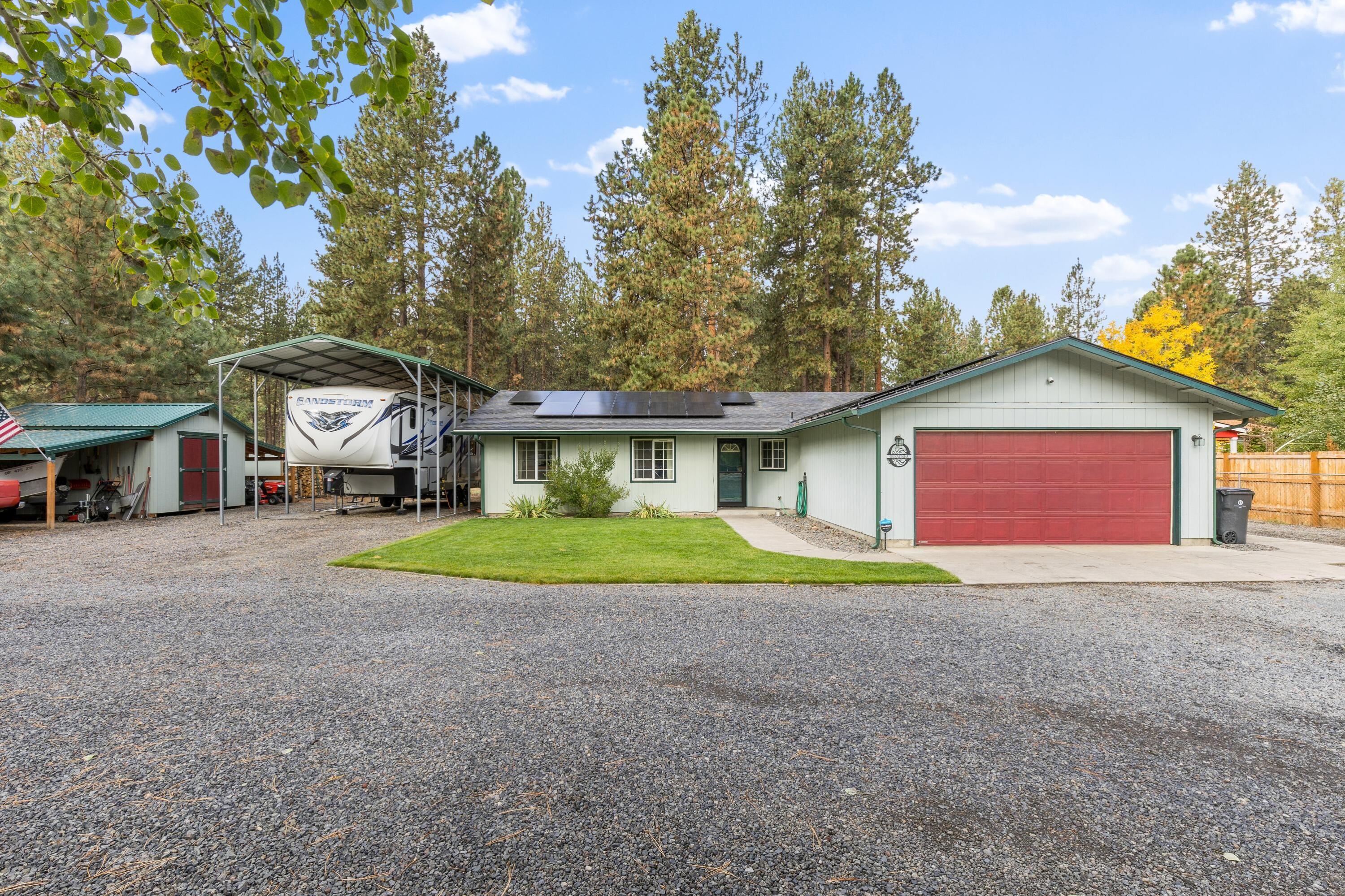 Experience simply peaceful country living just minutes from town at 59895 Cheyenne Rd. This pridefully maintained single level home offers the perfect blend of comfort and privacy on a 1.1 acre lot surrounded by towering pines. The floor plan offers a living room with a cozy wood burning stove, a well appointed kitchen, and a functional layout with the primary bedroom being separated from the two other bedrooms. Step outside to a large back deck overlooking a large and fully fenced backyard space with room for gardening, gatherings, or simply soaking in the Central Oregon sunshine. The home has a newer roof with solar panels, new leaf guard gutters, a metal RV storage/parking space with hook ups, a large shed and wood storage. With easy access to Bend's trails, rivers, and outdoor recreation, this property captures the best of rural tranquility and modern convenience. Come and call this home while being able to store all your favorite Central Oregon recreational toys right outside.