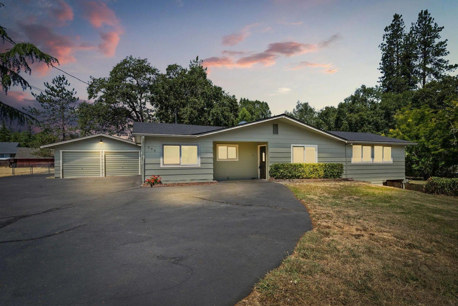Below market - Mini farm or extra space! Completely remodeled in 2022 with new roof, windows, HVAC, water heater, cabinets, appliances, and paint; exterior repainted June 2024. Located at the end of a quiet road just minutes from town and near Schroeder Park on the Rogue River. Features 3 large bedrooms, a spacious family room, living/dining with fireplace, breakfast nook, and laundry with abundant storage. Main bath has tub/shower; primary has half bath. Oversized 2-car garage plus second driveway with RV parking and carport. Large, flat pasture with 540 sf barn (new roof 2024) with stalls, chicken coop, hay loft, and garage. Also includes 880 sf building with shop, storage, and 2-car garage (roof ~5 yrs old). Irrigation rights from Grants Pass Irrigation. Former pool area ready for new installation. Block walls keep home cool in summer, warm in winter. 2-family potential—owner may sell adjoining .92-acre lot.