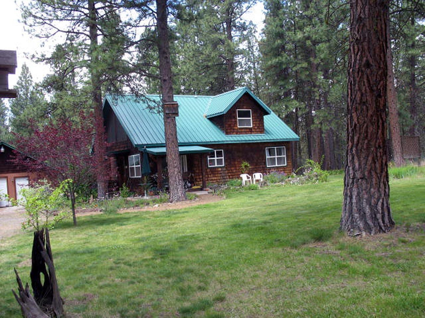 ) Looking for peace and quiet? Look no further! Well kept cabin on 2.5 acres! This home features 2 bed/1 bath, an open concept living with high ceilings, open kitchen with island, large loft for a second bedroom, F/A heat plus certified wood stove, metal roof. Oak wood flooring throughout the home except for tile in the bathroom/laundry rooms. Oak 6 panel interior doors. Outside, enjoy all the beautiful perennial flowers, herb garden, tall pines. Manual sprinklers used for watering. Property is fully fenced , approx 12X40 double walled greenhouse and a fenced garden area for tomatoes etc, RV parking/carport. Detached garage with an attached over hang for storage/wood storage. Nice patio area. Make this peaceful home yours today.