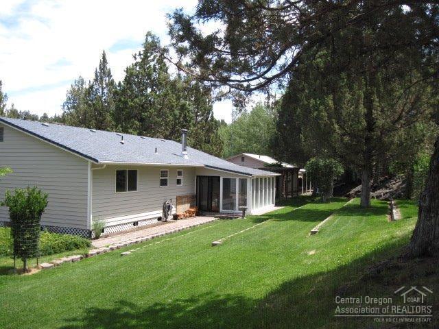 Oasis in the High Desert, surrounded by big shade trees and beautiful landscaping with extensive drip/sprinkler system. You'll feel like you're in a park, very private but minutes from town. This home has it all fully fenced, shop, huge greenhouse, gazebo, off paved road, RV hookup, plus a super energy efficient GEO Thermal heating/Air system. This 3bed/2bath plus man cave, could be used as a studio or Mother in law space, there's room for everyone. This home has too many features to list, it's a must see!