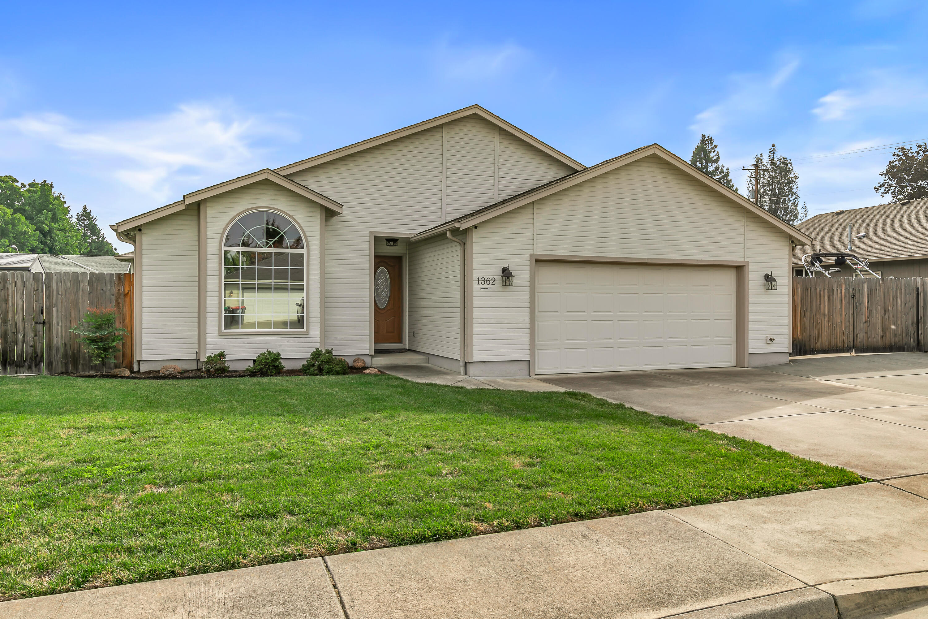 Incredible Central Point location tucked away in a quiet setting, this immaculate home is move-in ready with beautifully maintained yards front and back. Enjoy real oak hardwood floors, vaulted ceilings, crown molding, solid wood doors, custom paint, and plenty of natural light. Wonderful floor plan features a spacious primary suite with walk-in shower, dual sinks, and large walk-in closet. The kitchen shines with granite counters, undermount sink, stainless appliances including refrigerator, and custom cabinetry. Additional highlights include a jetted tub in the guest bath, tile in laundry and baths, recessed lighting, upgraded windows, and extensive storage throughout. Outside offers a large covered patio, paved RV parking, in-ground sprinklers, and two storage sheds including a custom shed with power. The oversized two car garage includes built-in cabinets and workbench. This property has been meticulously cared for inside and out and is truly priced to sell.