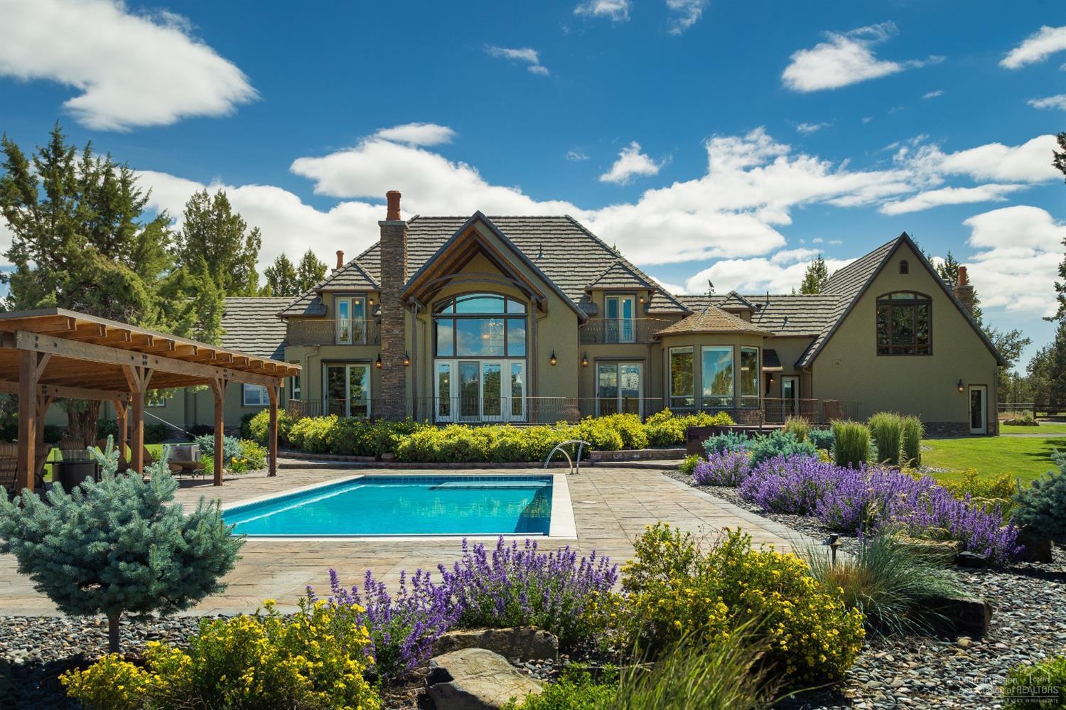 Located on a bluff overlooking the Cascades, find this exceptional Chateau inspired home where old world warmth blends w/modern design. Expansive windows provide views of pool, hot tub & mountains & a bright, airy feel. This 5831 SF home incl. 4 BD, 2 HB & 3 BA PLUS a mother-in-law suite w/ pvt entrance. Convenient Mud/Laundry Rm w/ dog wash station just off heated garage w/ storage & workbenches. Car enthusiasts will love the 2nd detached 2 bay pull-thru garage w/car lift, office, full bath & storage above. At rear is a Lg open, covered space allowing storage of toys, tractors, etc. Nearby are 240 gallon gas & diesel tanks making filling up a snap. Centrally located between Bend & Sisters in Sisters School District. Also for sale: 53.08 Ac of adjacent land w/ 45.5 Ac of pivot irrigation & 3 bay pole barn/shop. Now, a chance to own & entertain in a magnificent NW estate overlooking sweeping views of the Cascades w/ 57+ Ac of breathtaking land to live life to its fullest.