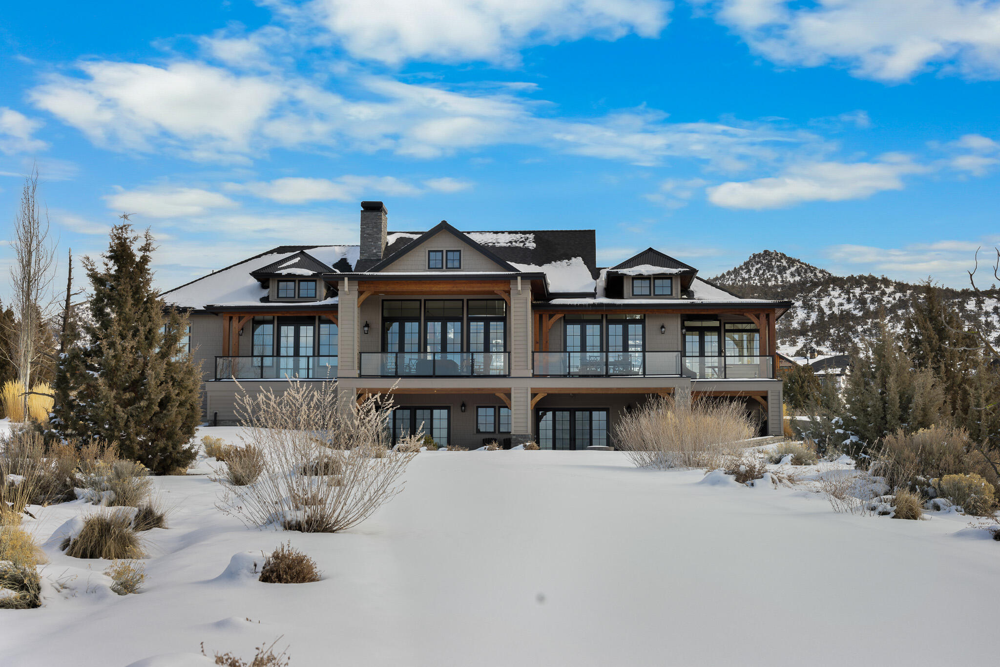 If you've wished for a contemporary French Country interior wrapped in a truly Brasada Ranch exterior, this gift is for you. Elevated homesite next to the 13th fairway of Brasada Canyons golf course, elegant interiors capture surrounding Cascade Mountain vistas. White-washed wide plank floors & custom cabinets, white walls & tile with a soothing neutral color pallet grace the entire home. Open kitchen features vaulted ceilings, quartz kitchen island & tile, Viking appliances, farm sink, & banquette. Expansive adjoining great room with dining & sitting areas with gas fireplace opens to large, covered deck with pavers. Primary bedroom on same floor with pass-through fireplace, vaulted ceilings, & grand en-suite bathroom featuring raised tub, walk-in closets, & private lav. Downstairs: two guest rooms with two full baths, built-in bunk beds, & entertainment area with wet bar. Large mud room with elevated tiled dog wash, half-bath, & laundry area. Detached three-car garage. Landscaped