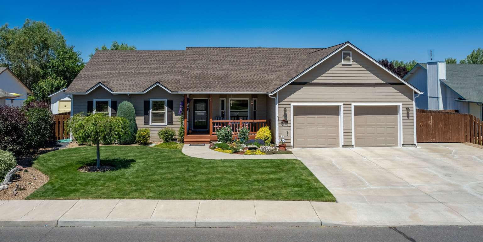 This delightful and charming home welcomes you into a lovely open living/dinning room area with cozy fireplace, vaulted ceilings, oak hardwood flooring, and a view onto the private back deck in a park-like setting backyard! It has a large kitchen with granite counter-top island, sitting bar, and an abundance of easy access cabinets, plus available hookup for either gas or electric range. A wide hallway provides access to the bedrooms and main bathroom. The primary bath has dual sinks, a walk-in closet and shower. The off kitchen laundry room has ample storage, a skylight, sink and an attached large 1/2 bath. A full house hot water circulation system is also included.
The expansive 3 car tandem style garage has a high ceiling plenty of built-in storage, open shelving and a workbench. A relaxing backyard has total visual privacy, raised covered deck, private spa, shade trees and raised garden beds. RV parking also has a 30 amp electric service hookup.