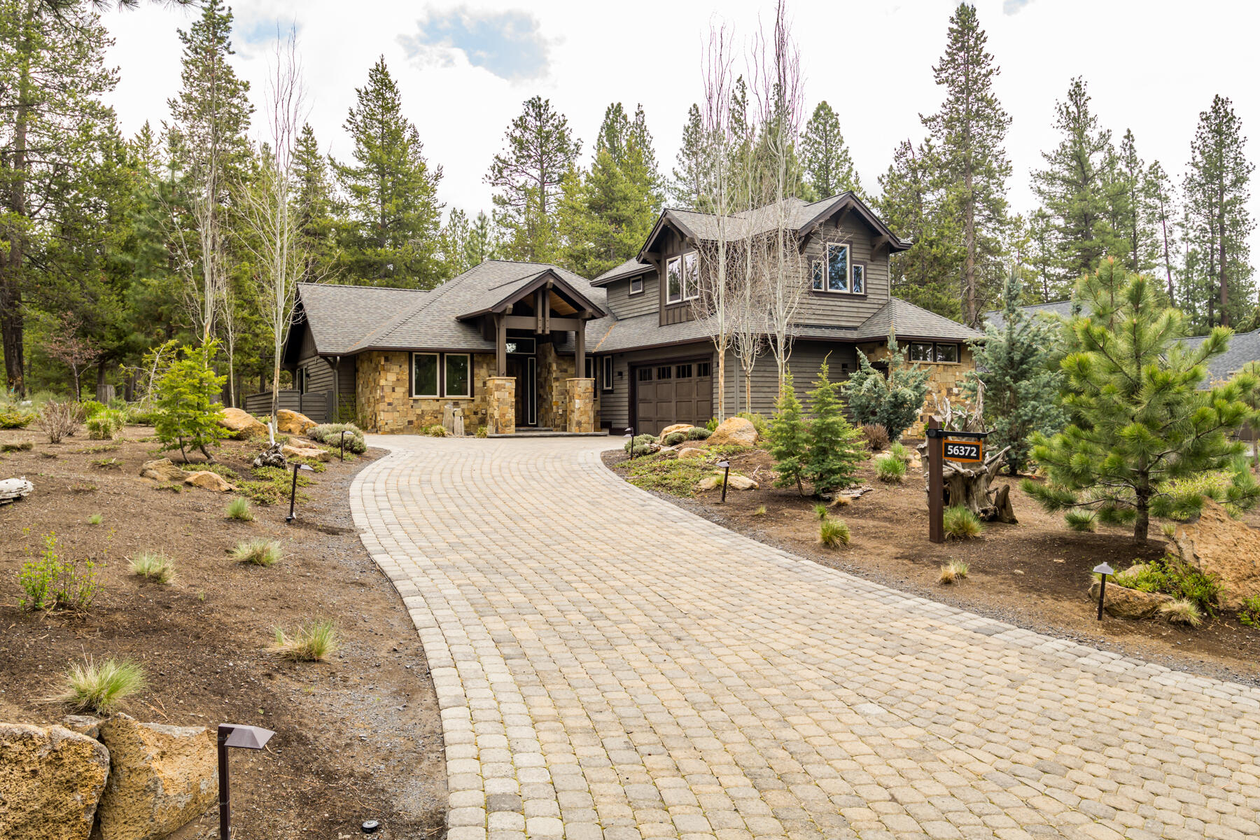 Set on a private 0.41-acre lot that backs to common space, this fully furnished mountain modern home offers a rare opportunity for turnkey resort living in scenic Caldera Springs. The hallmarks of quality craftsmanship are evident throughout, from the decorative paver driveway to the hickory wood flooring and cathedral ceilings with exposed beams. The open concept great room and kitchen feature granite countertops, high-end stainless appliances, a floor-to-ceiling stone fireplace, and access to an expansive back patio with two built-in fire pits. The versatile floor plan - featuring a primary suite, additional en suite bedroom, bunkroom, flex room, and office - is enhanced by smart upgrades like Ring security, high-speed ethernet, and a whole-home Sonos system. Eligible for STR but never rented, a low HOA fee grants access to a gated community with an impressive range of amenities, including several pools, pickle-ball courts, fitness center, 9 miles of trails, a restaurant, and golf.