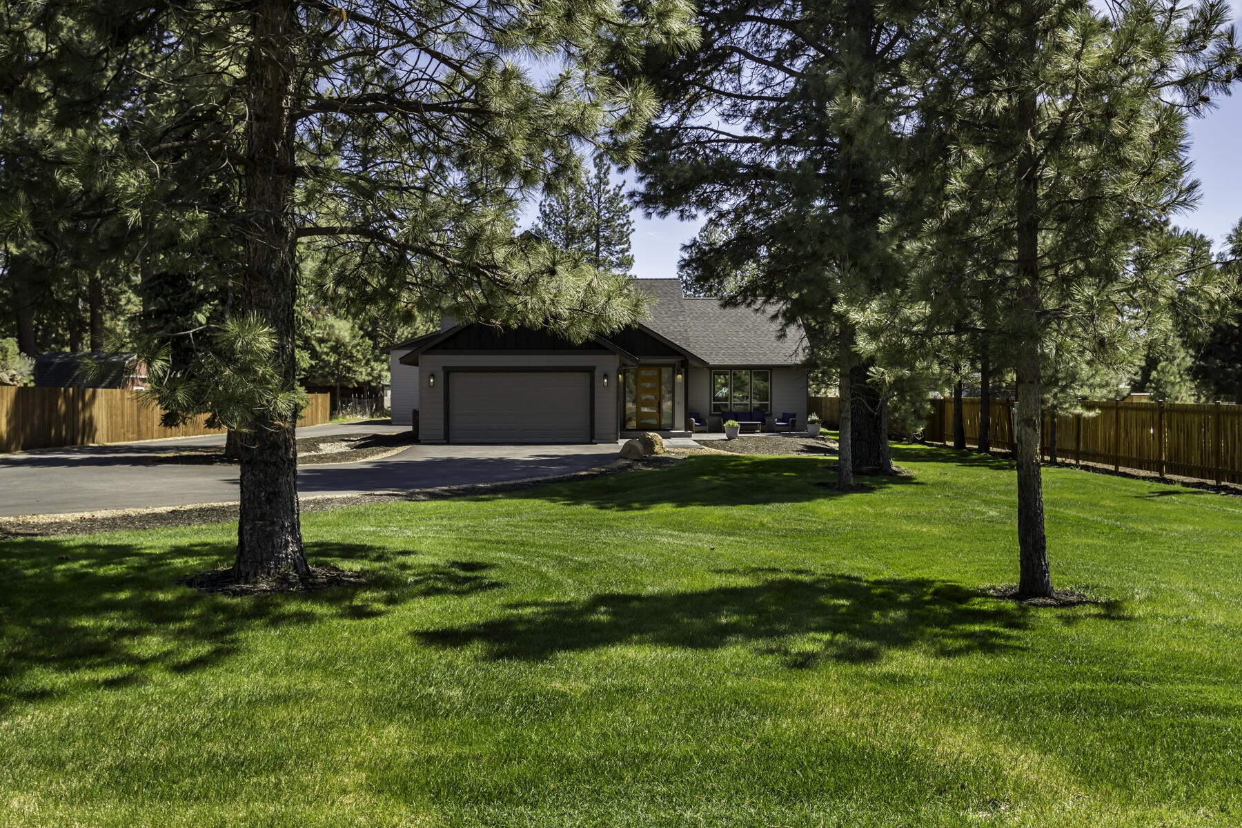 This exceptional 3-year-old custom-built home with a large shop and covered RV parking combines luxury, flexibility, and an ideal Bend location. Great possibilities  for multi-generational living or Airbnb w/ the vaulted flex room that includes quartz counters, sink, dishwasher, mini fridge, and microwave. The 3 bed/2.5 bath layout showcases walnut kitchen cabinetry,  pantry, quartz counters, vaulted open-concept living, and a stunning floor-to-ceiling stacked stone fireplace with inlaid walnut. European hardwood floors add warmth throughout. The primary suite features a tile shower and walk-in closet. Set on a fenced, landscaped 1-acre lot just minutes from Hwy 97, Brookswood Plaza, the Old Mill District, and downtown Bend. Outdoor living shines with a stamped concrete porch, large patio, hot tub, above-ground pool, and lush yard—a rare blend of country living close to town.