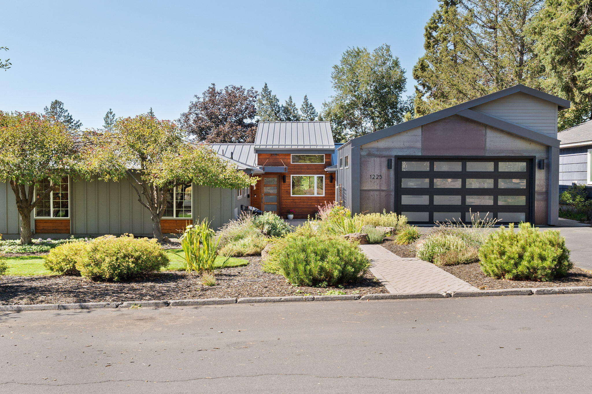 Stunning mid-century modern home on a beautifully landscaped .25-acre double lot in highly sought after Midtown Bend. Thoughtfully updated throughout with modern finishes & stylish details. The spacious dream kitchen features a commercial-style range/oven, plenty of storage & a large island perfect for cooking & entertaining. This single-story layout offers excellent separation between the  primary suite and guest bedrooms, creating comfort and privacy for all. A large bonus room with its own entrance & dedicated parking provides endless possibilities— a home office, studio, or convert it into an ADU. Step outside to your private oasis with 2 decks, a cedar sauna, cold plunge tub, cozy fire pit, and landscaped for privacy offering year-round beauty & seclusion. Additional highlights include an EV charging station, open-concept living, custom tile, a steam shower & abundant natural light. A rare blend of smart design & modern convenience in a prime location—this home truly has it all.