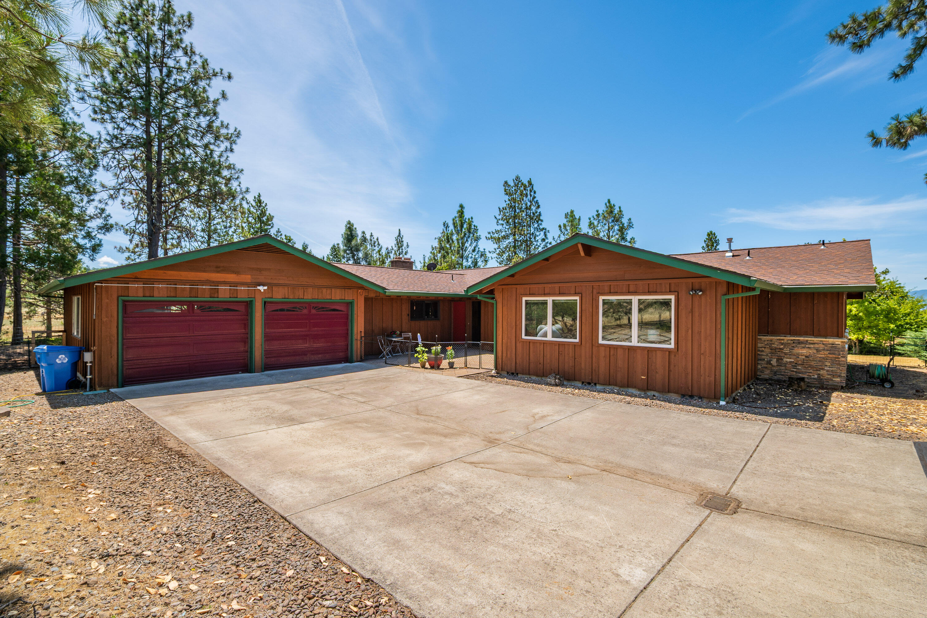 The paved driveway leads to a 2,981 sq ft, 4 bedroom 3 bath home on 4.99 acres of level useable property. The well appointed home has lots of large windows making it very light and bright inside. Living room has a cozy pellet stove and doors lead out to a beautiful Trex deck with a roll out awning. Downstairs is a family room with a wood burning fireplace. The kitchen has granite counters, tile backsplash, double wall ovens, lots of counter space, and an island with a sink and the dishwasher. The primary bedroom has large windows and french doors leading to a patio. A very nice tile shower, a soaking tub, granite counter, and a huge closet. The shop is 56x36 with 4 rollup doors, 1 is 14' tall. It also has its own off grid solar power system. There is an on grid solar system for the house with a production capacity of approx. 120% of the properties electrical needs. Both systems are fully paid for. There is more paved parking for your RV, tractor, toys or whatever next to the shop.