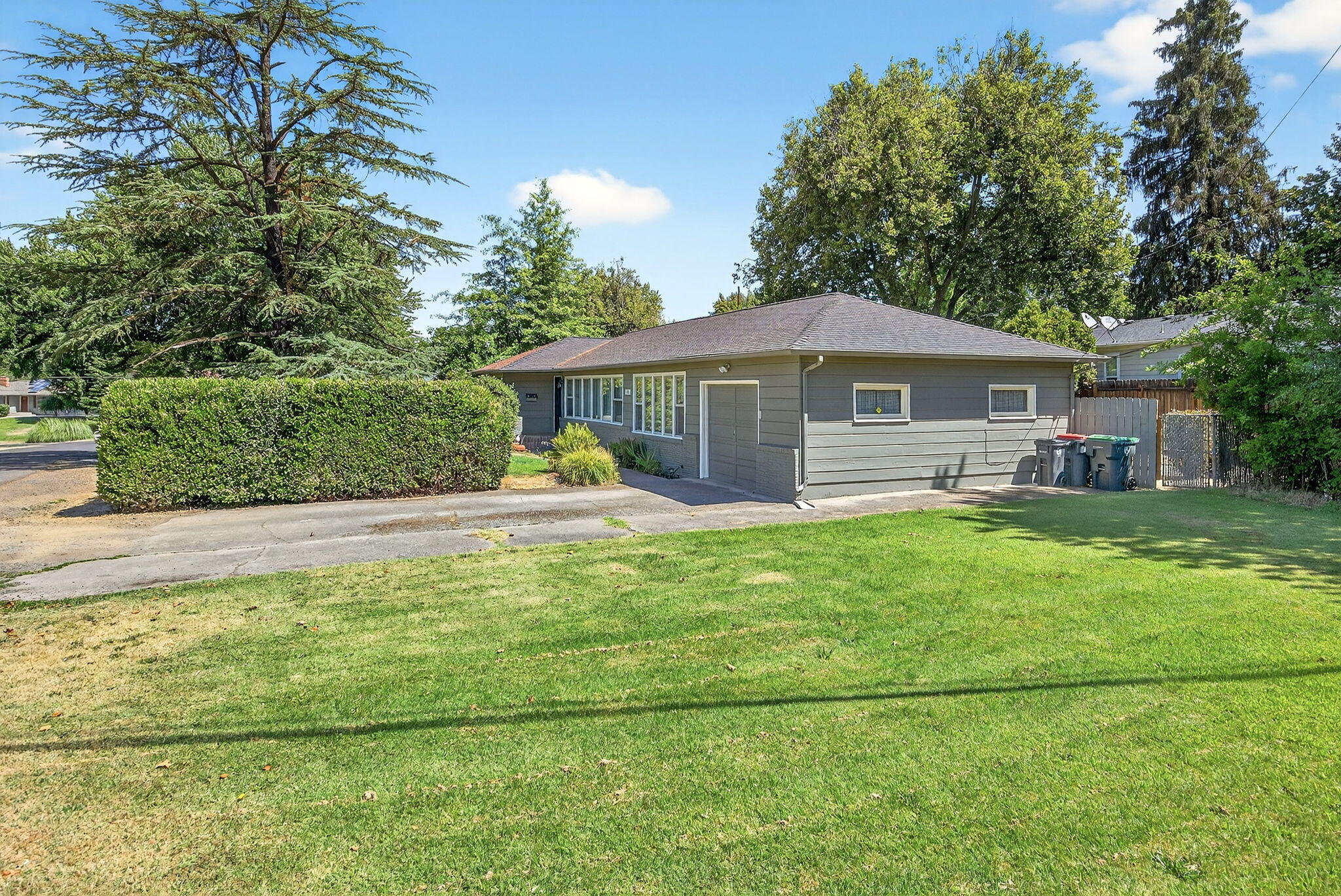 Charming Home on a Spacious Corner Lot in Old East Medford. This delightful 3-bedroom, 2-bath home offers 1,415 sq. ft. of comfortable living space on a generous corner lot. Featuring vinyl windows, newly updated flooring in the kitchen and spare room, and beautifully refinished hardwood floors throughout much of the home. The cozy living room includes a fireplace, perfect for relaxing evenings. The kitchen boasts ample counter space and abundant storage, while the indoor laundry area is roomy enough to accommodate a small office or workstation. Exit outside to enjoy a private, fully fenced backyard. The attached single-car garage offers plenty of space and convenient attic storage with a pull-down ladder. An oversized side yard provides great potential for extra parking, a garden, or even expanding the garage. Located near top-rated schools, shopping, and medical facilities, this well-loved home is full of potential and ready for its next chapter.