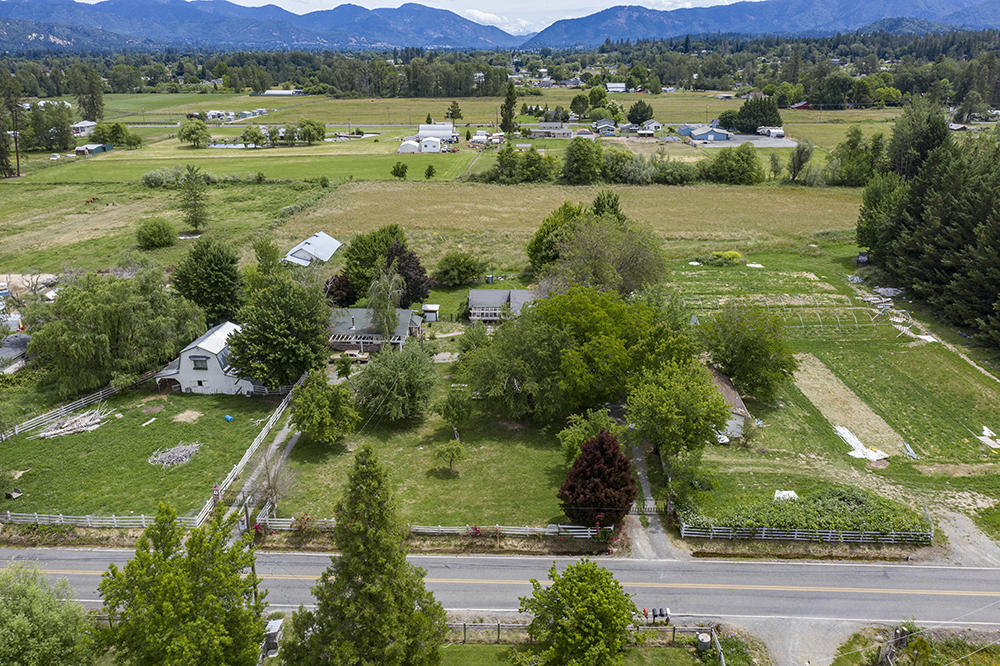 Almost 4 irrigated acres with two legal dwellings in the desirable Redwood area! This property has amazing potential! The gated entry opens to a beautiful circle drive with mature apple, cherry, and pear trees. The main farmhouse is just over 1900 SF with 3 bedrooms, 2 bathrooms, a sun room, and a large bonus room! The second home is a 2 bed, 1 bath that is
just under 1100 SF. Both homes have been tastefully updated with reclaimed wood and other modern accents. This property has 3.72 acres, a barn, and plenty of pasture for your own little farm! The adjacent parcel is also for sale and would add 3.83 acres and a 2 car garage! The property is in an excellent location with a beautiful view of the mountains offering quiet, country living close to town! Call for a tour today! This one won't last long!