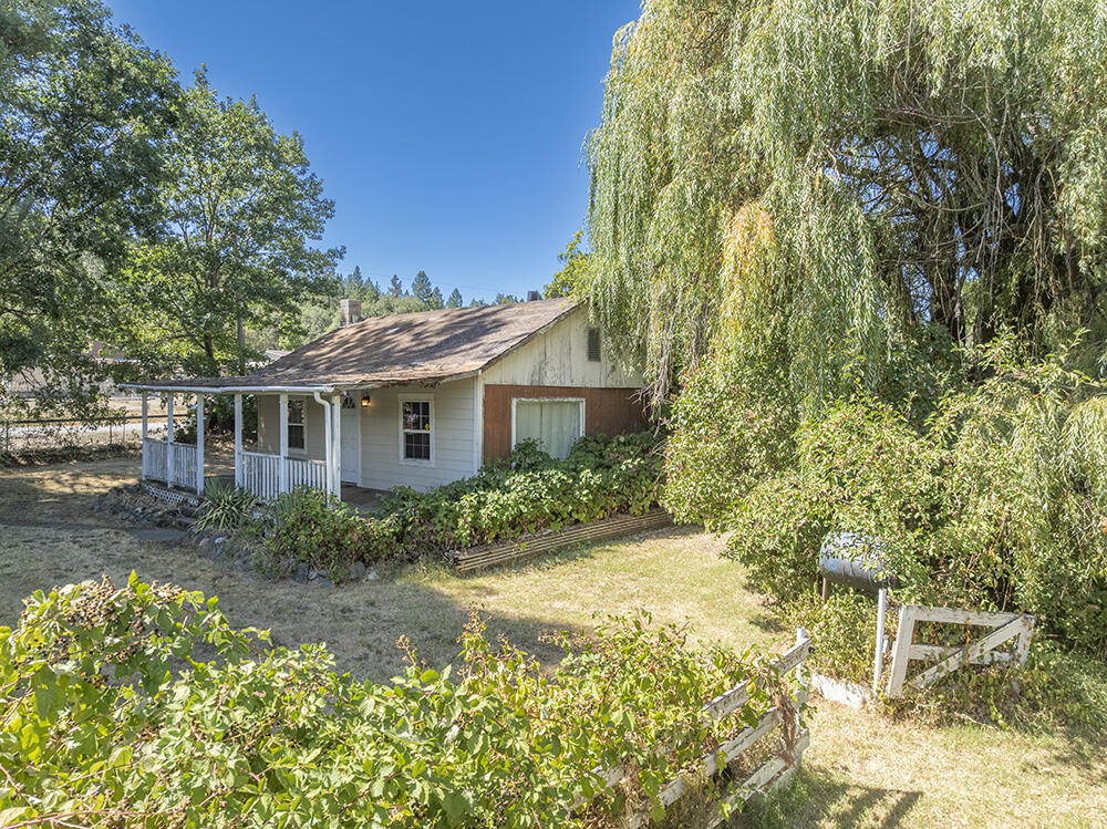 Perfect Fixer/Project Home on just over an Acre of Land between Grants Pass and Murphy! This Cottage-Style Single-Level Home was lived in until recently, but is in need of Cosmetic and Structural Work. The Home is Dry inside, and does offer some Good Floor Plan Features. Additionally, the Property has a Nice Shop-Type Building, that has the makings of an ADU/Guest Quarters or a Cool Studio Space. There was a Hardship Dwelling in place on this Property for many years, so the benefit of an Additional Separate Access and Water and Septic Connection is available. The Land here is Level and Useable, with Pretty Mountain Views, Numerous Fruit Trees, Garden Space, and a HUGE Awesome Redwood Tree! Ideally located just a few minutes away from Town, and perfectly set up for Animals and Kiddos to roam and enjoy. If you have been looking for a Bargain, or a Project to Earn Equity from your own efforts, this is the one for you. Priced literally at Land Value, but with so much more to offer!