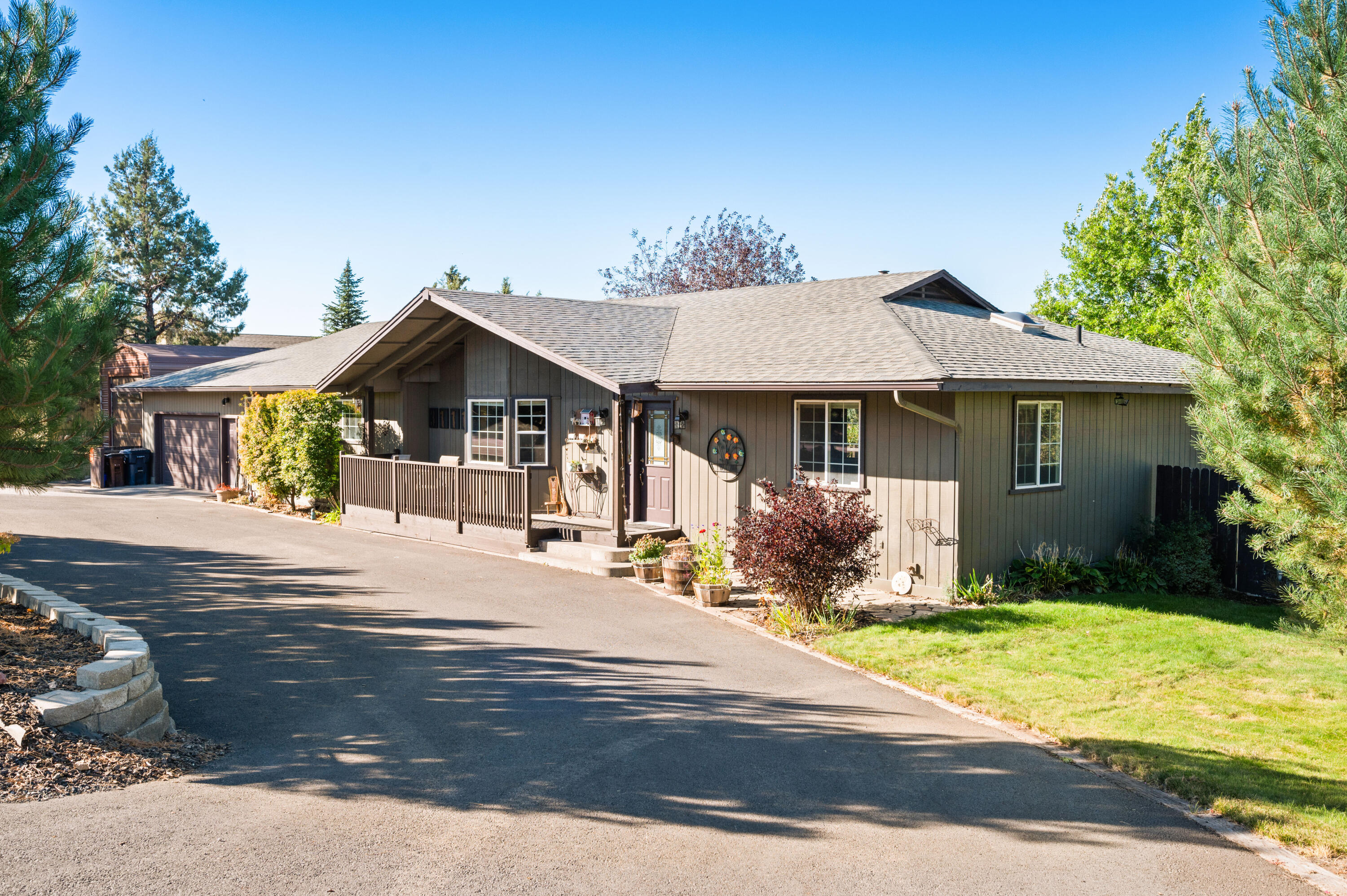 Welcome to this inviting single-level home with a warm mountain lodge feel. Featuring 3 bedrooms, 2.5 baths, and 2,450 sq ft of thoughtfully designed space, this home blends comfort and character throughout. Enjoy bamboo and tile floors, solid surface counters, stainless steel appliances, double oven, cooktop, and an island with room for two stools—perfect for gatherings. A rustic barn door opens to a spacious laundry room with tall cabinetry and room for a desk. The great room offers a step-down living area and a striking wood panel accent wall. The primary suite is set apart from the two guest bedrooms and bath for added privacy, complete with a clawfoot  tub & tiled walk-in shower. Outdoor spaces shine with a  partially covered east-facing front deck for morning coffee and a covered rear deck with Cascade views. The large fenced yard features mature landscaping, garden beds, and automatic sprinklers. An extra-deep 864 sq ft garage with a ½ bath adds convenience.
