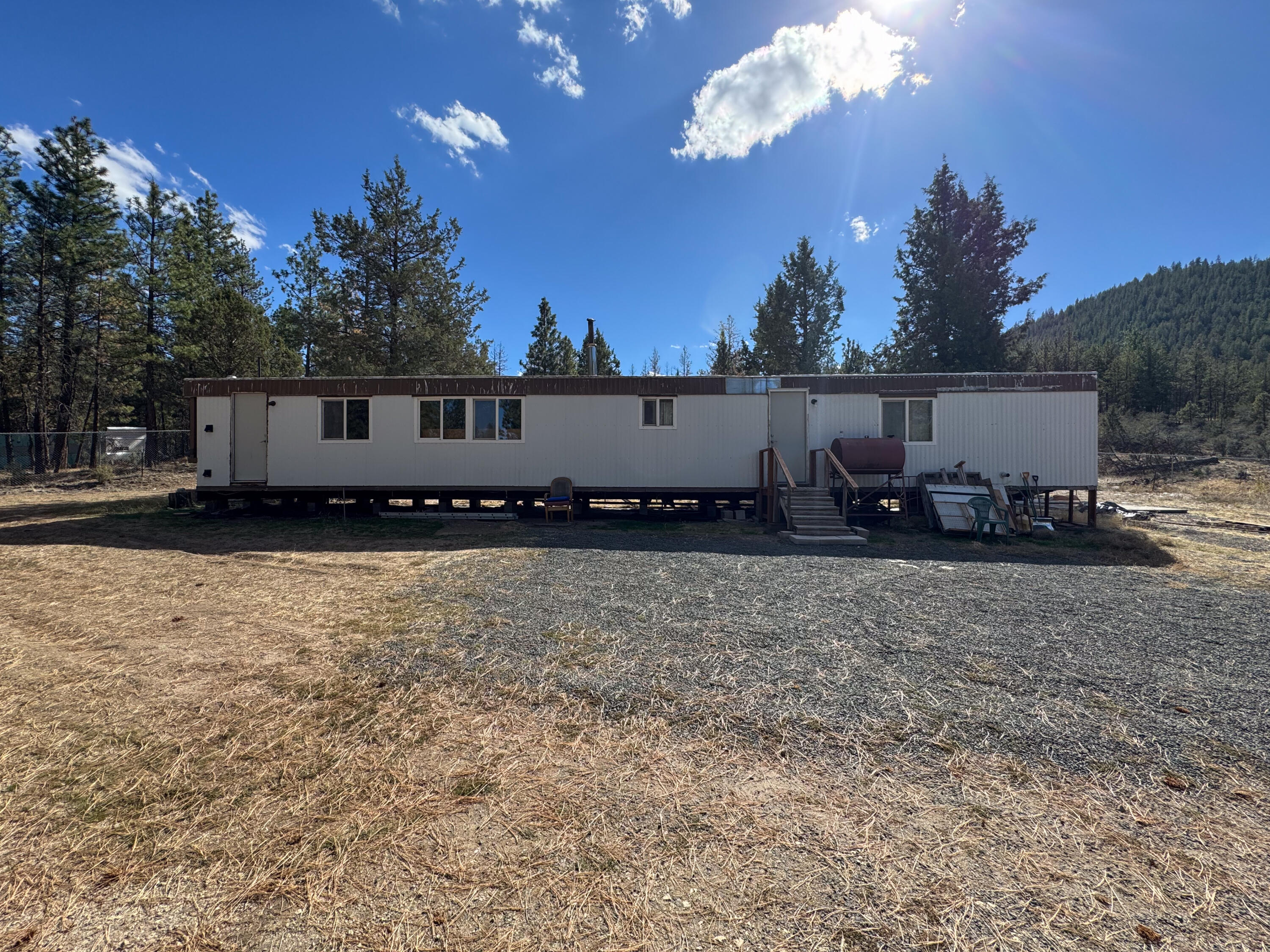 Situated on four parcels totaling 5.38 acres, this forested property offers privacy, acreage, and easy access. 

The main home has been set up for off-grid living, with established utilities that include an existing well, cisterns, septic system, and a propane tank. It also includes an instant hot water heater, new flooring and a fenced area surrounding the home.

With multiple parcels, natural tree cover, and existing improvements, this property is well suited for buyers seeking land, privacy, and the ability to create a property that is truly your own. Check out the photos and reach out to see it in person.

There is a second manufactured home that is in need of major repairs.  This property will be sold as-is.