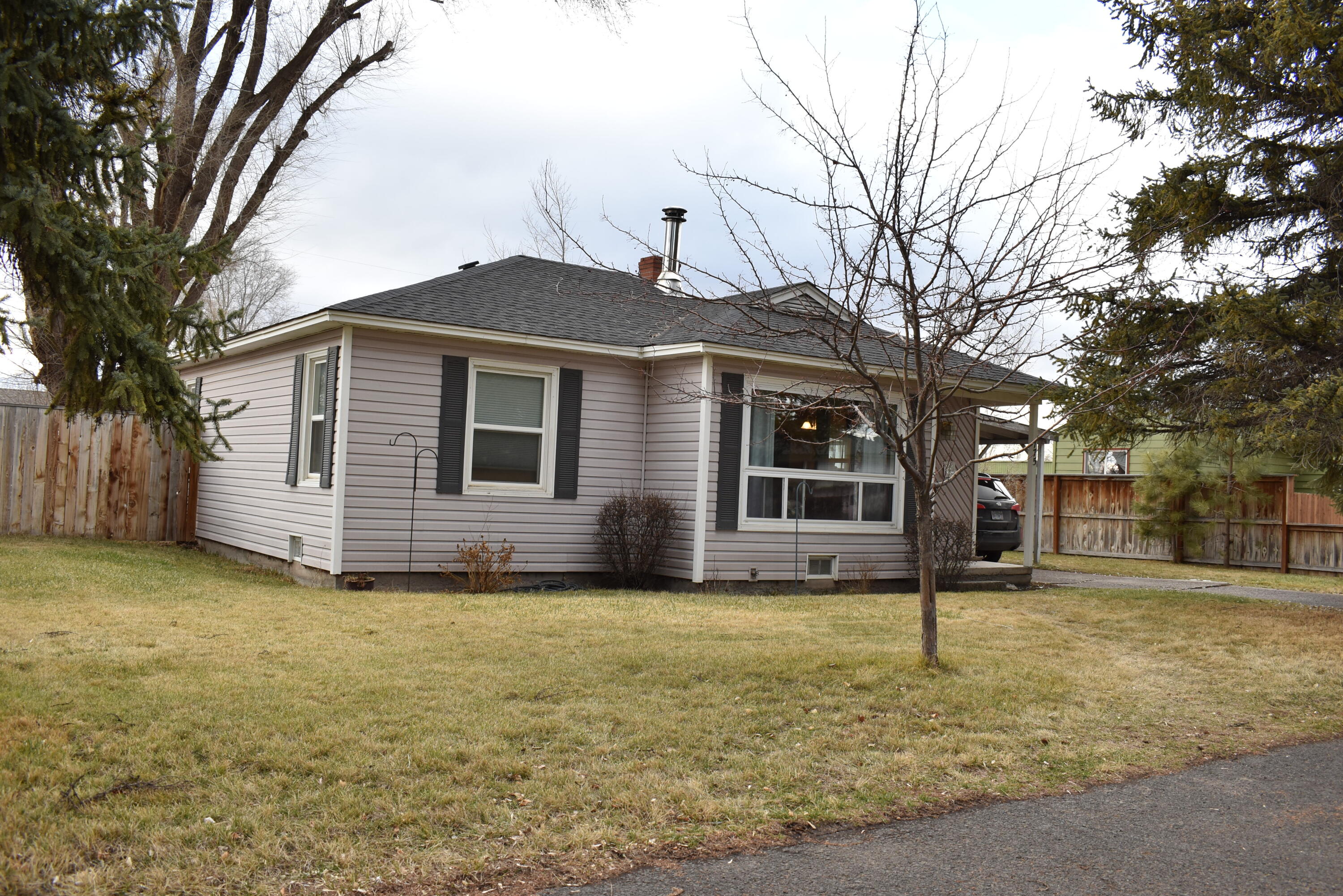 Very cute, well cared for 2 bed, 1 bath home in quiet neighborhood. Close to schools, fairgrounds, parks, dog parks and shopping. Original hardwood flooring throughout living, dining, hallway and bedrooms. Larger bedroom is carpeted, but has original hardwood flooring underneath. Large fenced back yard with storage shed on concrete pad. Stay warm in the winter with the wood stove and a natural gas furnace. Concrete driveway and attached carport. Great opportunity for homeowners or investors!  Don't miss out on this one! Call today to schedule a private showing!!