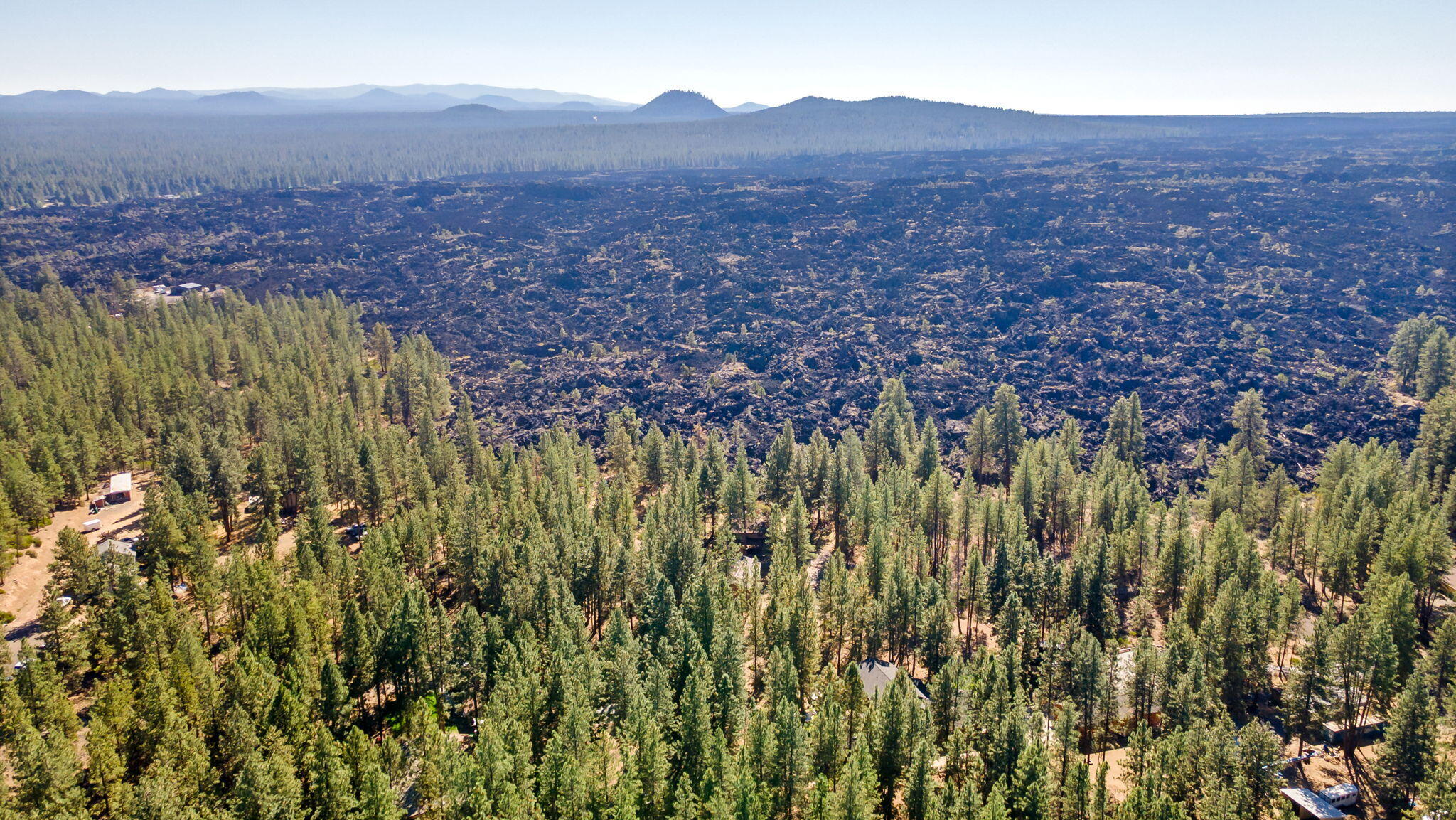 Discover the untamed beauty of Central Oregon with this unique 2.84-acre property nestled beside the breathtaking Big Obsidian Lava Flow from the Newberry Volcanic Crater. Towering pine trees offer privacy, shade, and a true sense of serenity on this secluded Southwest Bend parcel.
The land features a 2,339 sq ft home that's ready for your vision. Whether you want to renovate, restore, or start fresh with a custom build. Plus, enjoy the added value of a 1,500 sq ft heated shop, perfect for hobbies, storage, or a home business.
With direct access to some of the region's most striking natural features and endless recreational opportunities nearby, this property is ideal for anyone looking to create a one-of-a-kind retreat in the high desert.