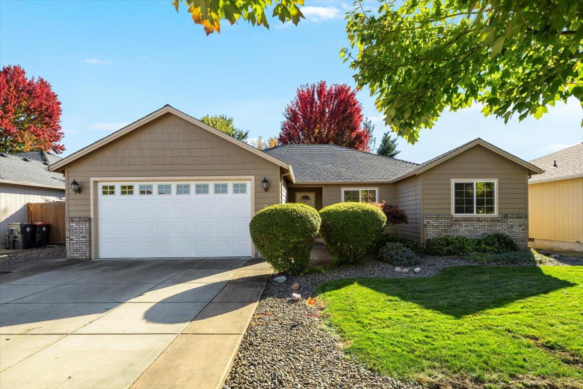 Beautifully maintained East Medford home with an open, light-filled floor plan! Built in 2004, this 3-bedroom, 2-bath single-level features 1,808 sq. ft. of comfortable living space. The great room offers vaulted ceilings, recessed lighting, a cozy gas fireplace, and large windows overlooking the private backyard. The kitchen includes granite counters, a center island with seating, stainless-steel appliances, and ample cabinet space, opening seamlessly to the dining and living areas. The primary suite boasts a tray ceiling, walk-in closet, and ensuite bath with dual sinks, updated tile shower, and soaking tub. Two additional bedrooms provide flexible use for guests, home office, or hobbies. Enjoy a covered patio and fenced yard shaded by mature trees—perfect for relaxing or entertaining. Hardwood floors, an interior laundry with storage, two-car garage, and easy access to shopping, schools, and I-5 complete this move-in-ready home.