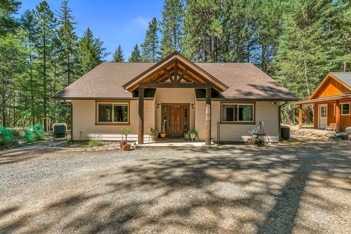 Soaring ceilings and large windows bring the outdoors in, filling this 1,900+ sq ft home with natural light and forest views. Set on nearly 5 acres with mature apple, cherry, and pear trees, the property is often visited by deer and wild turkeys. Inside, you'll find granite countertops, hardwood floors, and custom tilework, with a spacious primary suite upstairs and two bedrooms downstairs—one with a private exterior entrance, ideal for guests or multigenerational living. A 16' x 12' shed with loft, prepped for electricity and plumbing, offers flexible use as a workshop or storage. Additional features include a functional chicken coop, a covered RV area with full hookups, two gated entries, two septic systems, and an overproducing well. Perfect for hobby farming, self-sufficiency, or simply enjoying peaceful rural living.