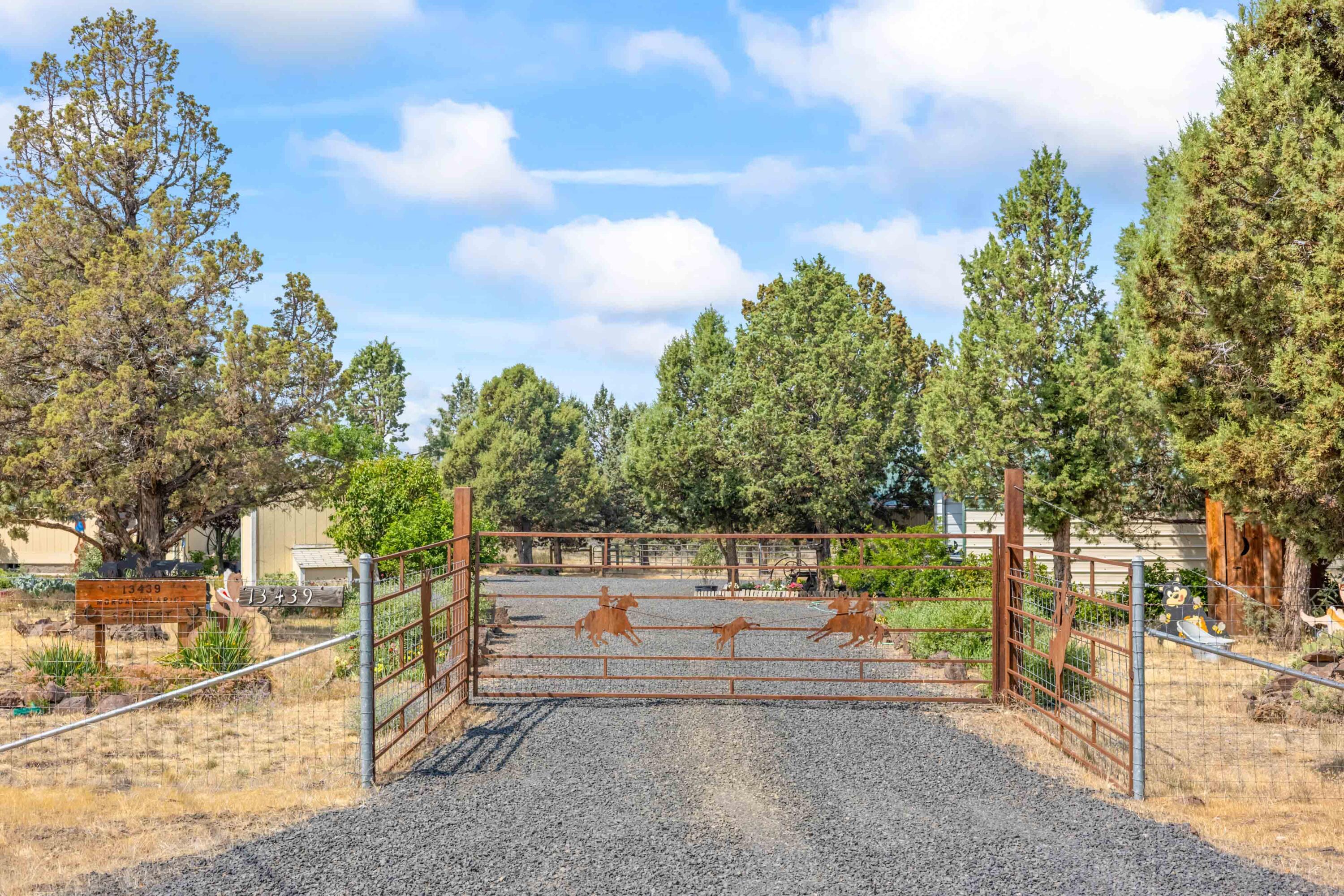 Bring the horses, goats and chickens and homestead on this 2 acres. Fenced and cross fenced and located on paved road. 1856 square foot, 4 bedroom, 2 bath home with double attached garage, barn with 3 stalls, workshop, greenhouse and chicken coup. Home has some updating recently with primary bath walk in shower. 14x20 patio with pergola cover and fun water feature with lily pads and fish. 8x10 front deck and concrete sidewalks front and back. Western front on greenhouse and poultry coup.  3 ton hay storage and attached workshop. Nice small horse set up with corral. Very good producing well. Extraordinarily landscaped with beautiful trees and flowers. Carport for boat or RV. Gated driveway with lots of turn around space and parking area. Home is vacant and ready for new occupants.