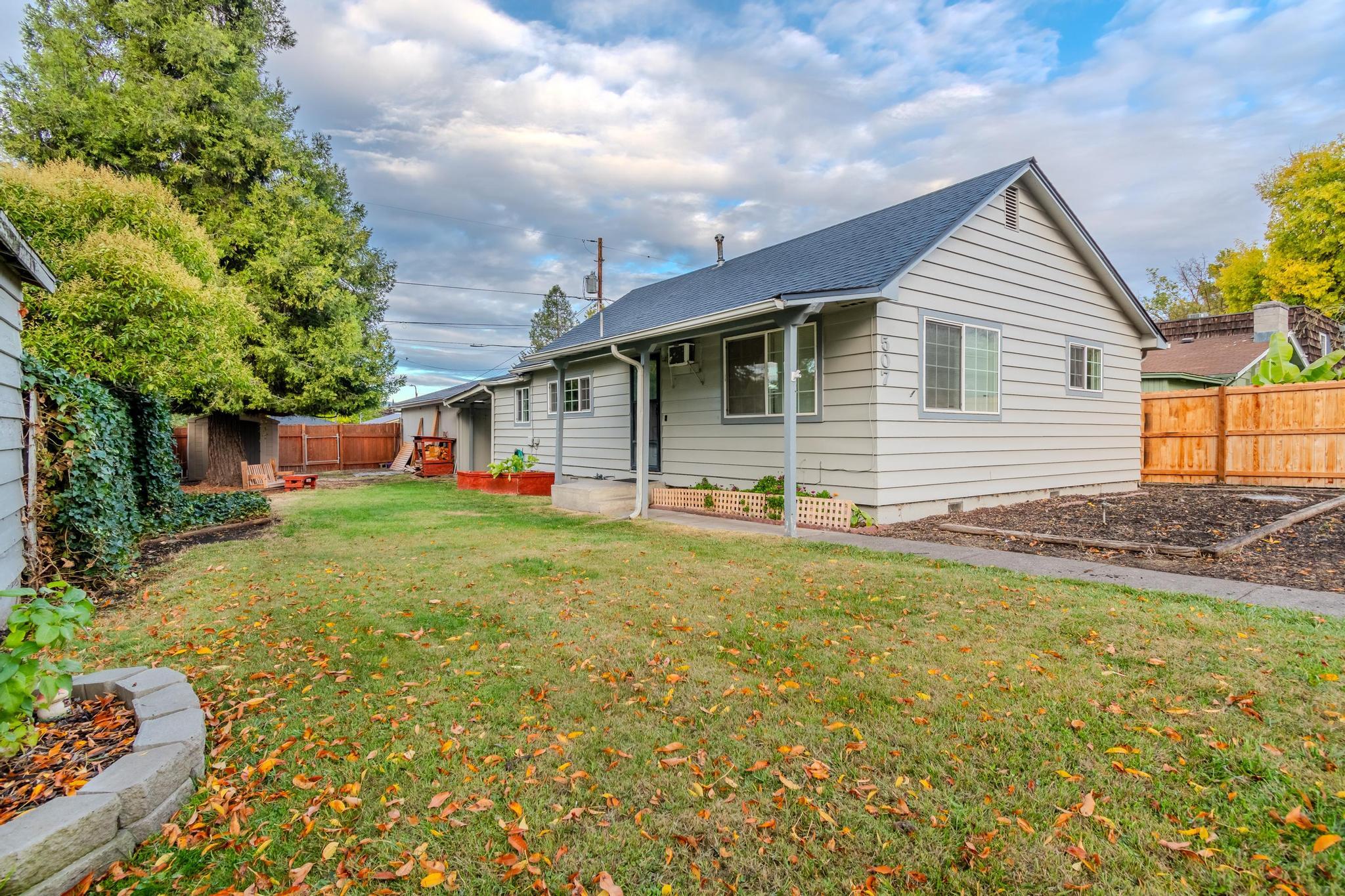 Discover this charming 3-bedroom home in the East Medford area, perfect for first-time homebuyers or savvy investors. This property boasts a 2-car garage with a built-in workshop bench, ideal for DIY enthusiasts or hobbyists. A covered breezeway adds extra outdoor living space, connecting to a fully fenced yard that ensures privacy and security. The home features a kitchen with an island for additional prep space, seamlessly flowing into an adjoining dining area perfect for family meals. With its well-maintained 1-bath layout, the home optimizes living space efficiently. Convenient alley access adds to the property's appeal, making it a standout option in today's real estate market. Don't miss this opportunity to own a slice of East Medford's charm!