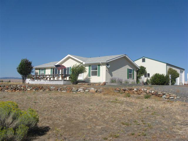 MF Home on 5 acres w/fabulous mt views, 3 bed, 2 bath, open floor plan, pantry, utility room, appliances, carpet, laminate & vinyl flooring, forced air electric heat, landscaped, deck,orchard, garden, 1130 sq ft 3 car garage with one tall RV bay,shop, fruit room & attached garage. $159,500 ($178,000) #706