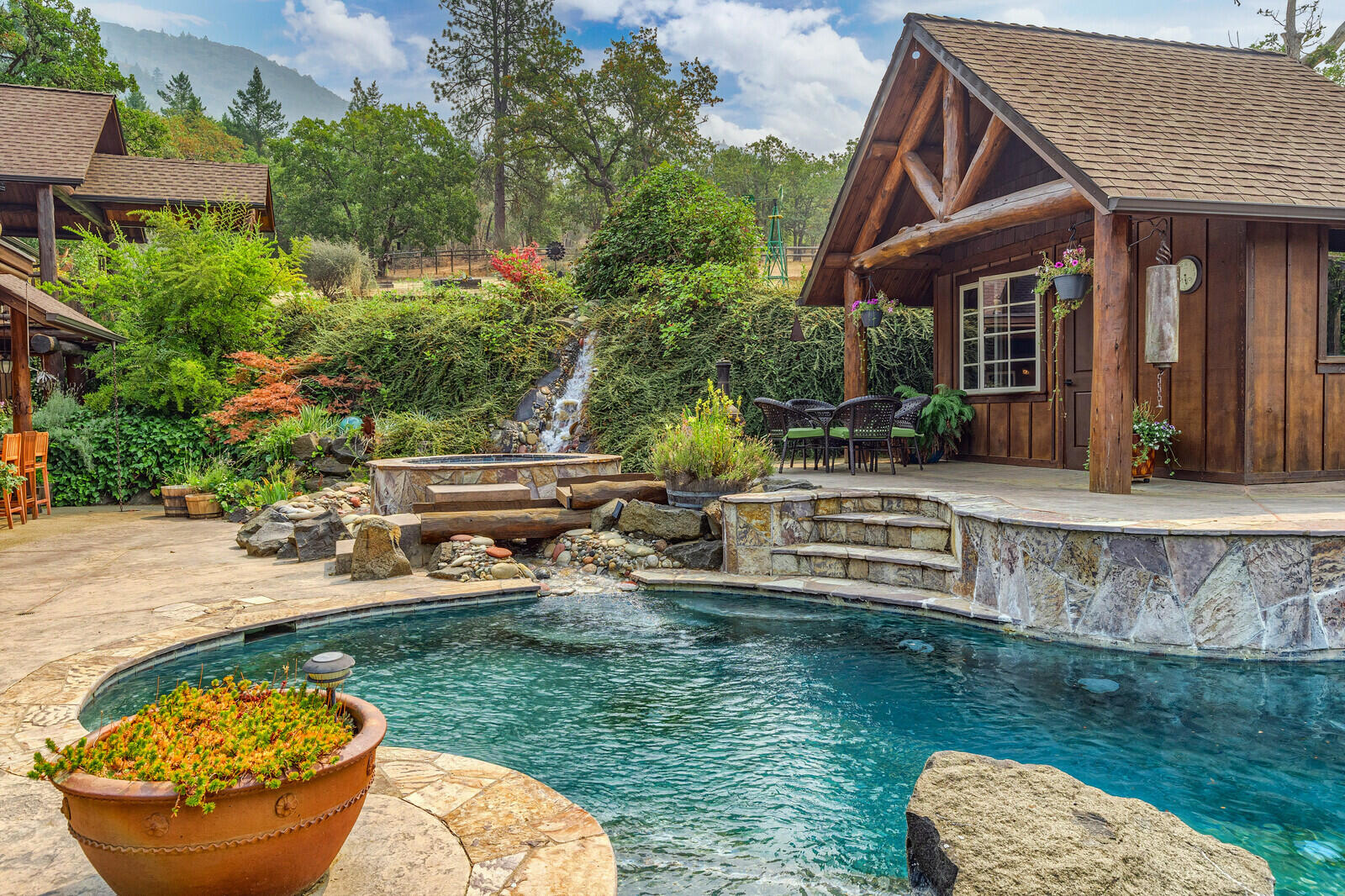 Lodge-style dream home with remarkable views, privacy & feeling of seclusion. Nestled on just under 4 acres (30 contiguous acres available see MLS 220129480) with all the amenities you hoped for. The home will wow you with vaulted ceilings, heated floors, gourmet kitchen with 2 islands & first-floor master suite overlooking the incredible resort style pool. Cedar siding, log posts, waterfall & pond with large boulders gives a solid presence to the home which opens to the exquisite saltwater pool, spa, waterfall, pool house, & outdoor kitchen. The second floor has 2 bedrooms, bath, family room, spacious covered deck with bridge walkway to the beautiful yard & garden with long range views of the valley. Paved drive leads to 40x64 shop with guest quarters, 2 horse stalls, feed/tack room. Near the entrance to Applegate Valley & wine country minutes to downtown Grants Pass. The exceptional location provides solitude without sacrificing convenience.Link to video: https://youtu.be/d0PnCMMTGDM