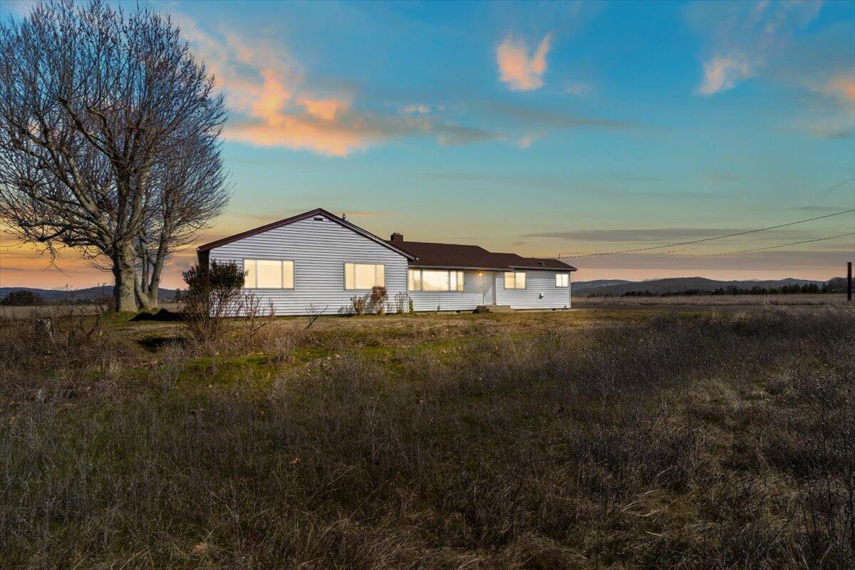 Enjoy peaceful rural living with 21 flat usable acres to have farm animals or just enjoy the view of nobody living close behind you. The huge trees and lawn space all around the house ties into patio space out back,  great for lounge chairs and relaxation. An extended paved parking area provides RV and extra parking. The large garden area makes easy planting for fruit trees and vegetables. Inside you will enjoy a floor plan with large view windows throughout, built-in closets and cabinets in all 3 bedrooms, and an office with a built-in desk and bookcase. A large kitchen has extra counter space, cabinets, and breakfast nook viewing wildlife in the ponds across the way. The home has its original beautiful true hardwood red and white oak flooring that has just been completely repolished and sealed. There is interior paint, bathroom and kitchen updating. There is newer hvac heating and cooling. Everything you've always wanted in country living is here. Listing agent related to seller.