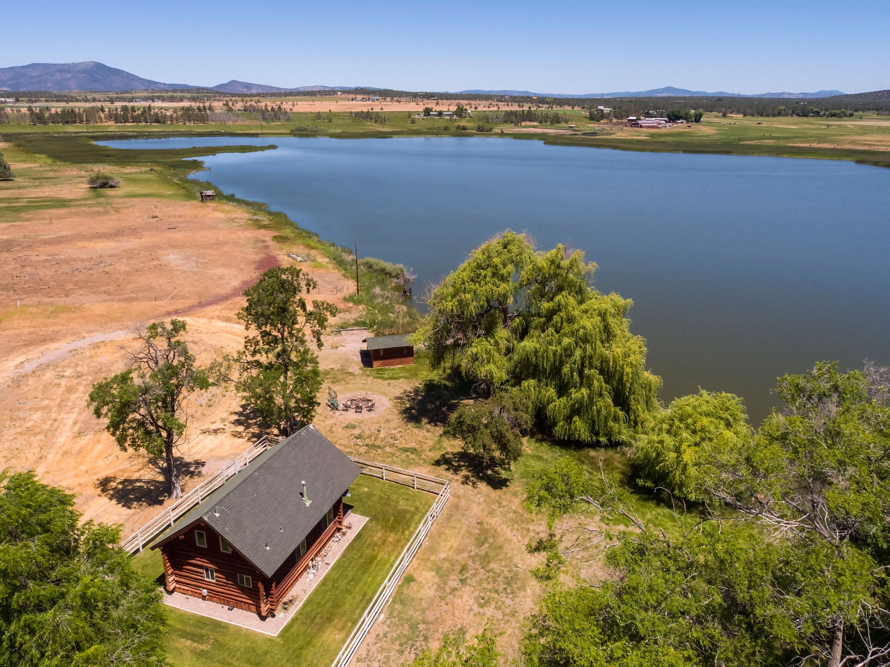This Oregon property is a playground for all of what Central Oregon is all about. Houston Lake Ranch is a 233+ acre ranch that sits just minutes from Powell Butte and 20 minutes to Bend/Redmond airport. Fishing enthusiasts will be amazed at the variety of fish found in the lake. Brook trout, crappie, whitefish, bass, catfish, rainbow trout, bluegill, carp, brown trout, and others are just waiting for a line to be thrown in. Houston Lake Ranch provides a refuge for a plethora of bird species that thrive by the lake. There are duck blinds, a boat house, and plenty of room to find the perfect spot on the lake for the waterfowl hunter. The irrigated land provides 3 fences of pasture for grazing and haying for livestock. With amazing Cascade mountain views, a 60-acre lake, 79 acres of irrigation, abundant wildlife, and a modest log cabin sitting steps from Houston Lake, this property is and will be a legacy ranch for generations to come.
