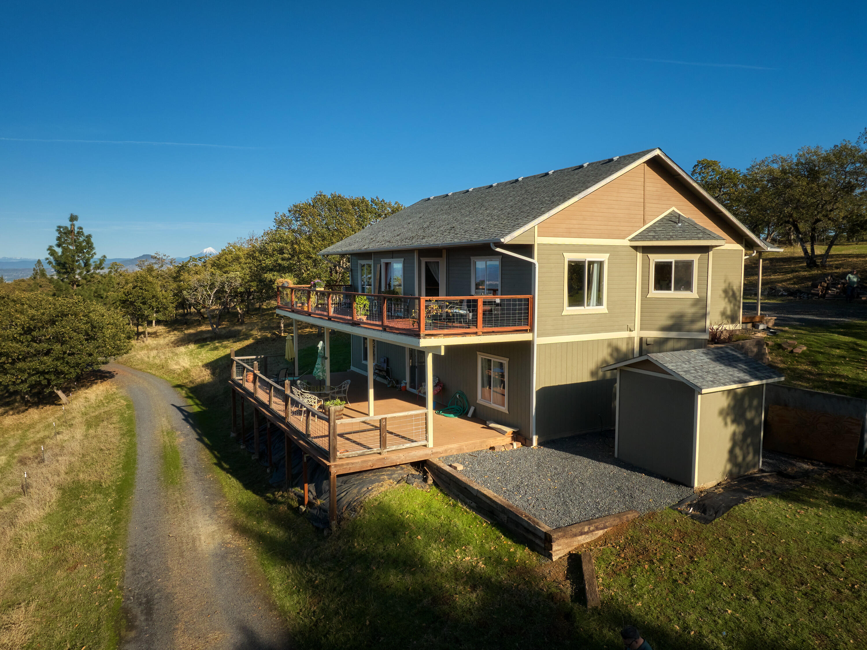 Hilltop Seclusion with views across the Valley. Minutes from Jacksonville with paved road all the way to the drive. Over 36 acres to ensure your privacy. 2911 sqft., 3 bed 2 1/2 bath, office (that could be made into a fourth bedroom,) primary suite on entrance level, great room layout, high ceilings, with magnificent views. Two large decks to take in the scenery and plenty of room for your horses or 4H/FFA projects as well as extra space for your garden. Large shop (1760 sqft.) with roll up door, office, loft, and bathroom. Shop has room for multiple cars, or could be used as a studio.  Buyer to do their own due diligence regarding possible uses and future development of this property. This property is NOT a drive-by, appointment required.