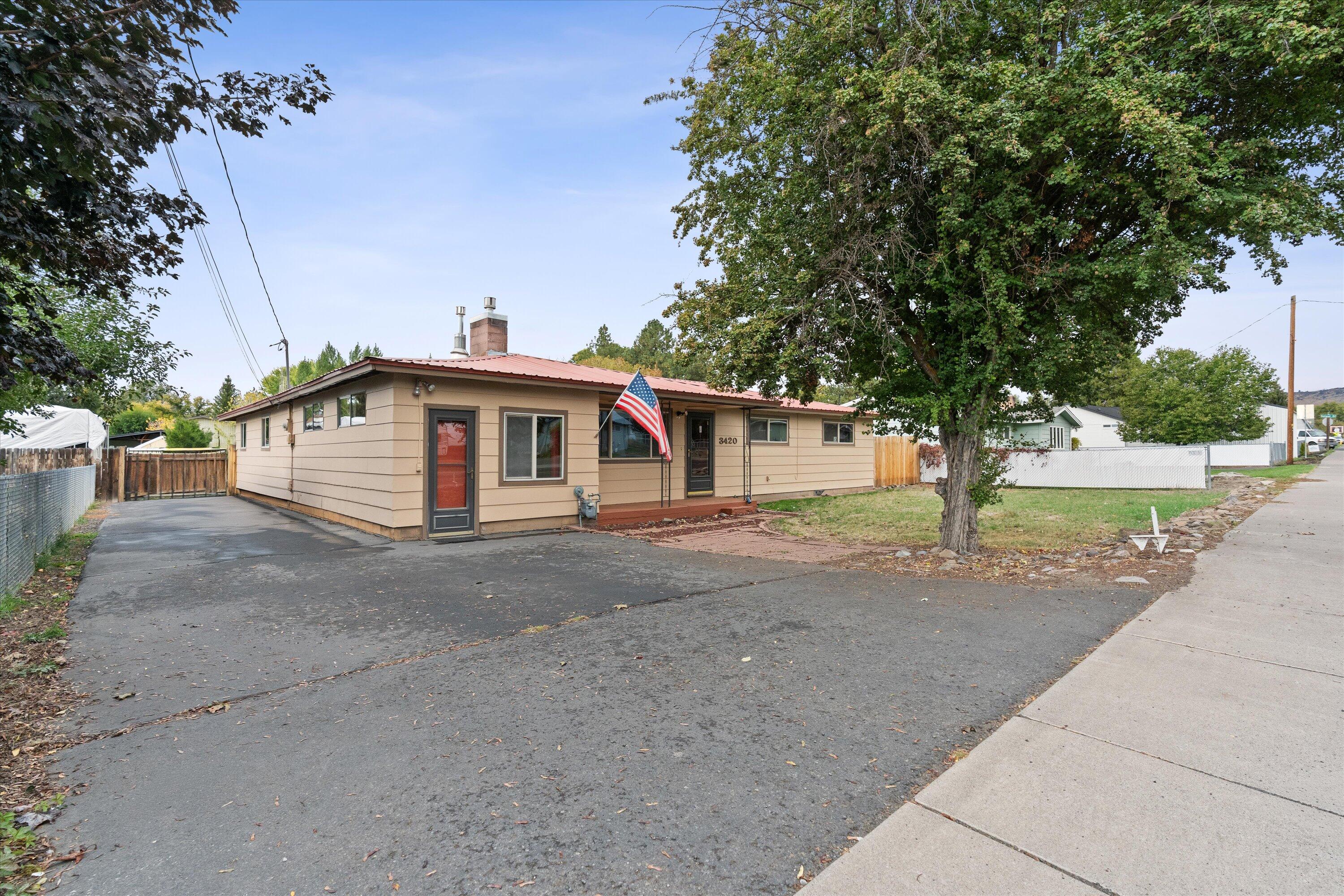 Spacious ranch-style home on a large lot. Located in a desirable Klamath Falls neighborhood, this single-level home has never been on the market and features 5 bedrooms, 1.5 baths, and multiple living areas. The layout includes a family room, living room, dining area, bonus room, and laundry, offering flexibility to suit your lifestyle. Enjoy cozy evenings by the gas fireplace or relax outdoors on the large deck, covered deck, or covered front porch. The 0.29-acre lot includes a level yard, two storage sheds, RV parking, and a durable metal roof for peace of mind. With its ample floor plan and excellent outdoor amenities, this home is ideal for those seeking comfort, functionality, and room to grow.