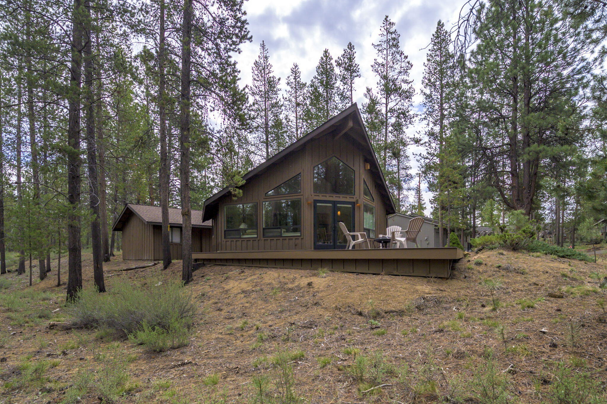 Welcome to this enchanting chalet-style abode nestled in the vibrant Sunriver community. This architectural gem offers a perfect blend of rustic charm with modern sophistication & elegance, making it an exceptional find. You are greeted by a spacious & light-filled living area with tongue & groove vaulted ceilings. The open floorplan seamlessly connects the living room, dining area, & kitchen, creating an ideal space for both entertaining & everyday living. Adjacent to the living area, French doors open to an outdoor deck with views of mature trees providing peace & tranquility. The primary suite is complete with a modern walk-in shower & spacious closet. The second bedroom & sleeping loft offer ample space for family & guests, while the second bathroom features convenient dual shower heads. A paved driveway leads to a spacious two-car garage, providing ample parking space for your vehicles. Located near SHARC, Sunriver Village, & scenic trails, with easy access to major highways.