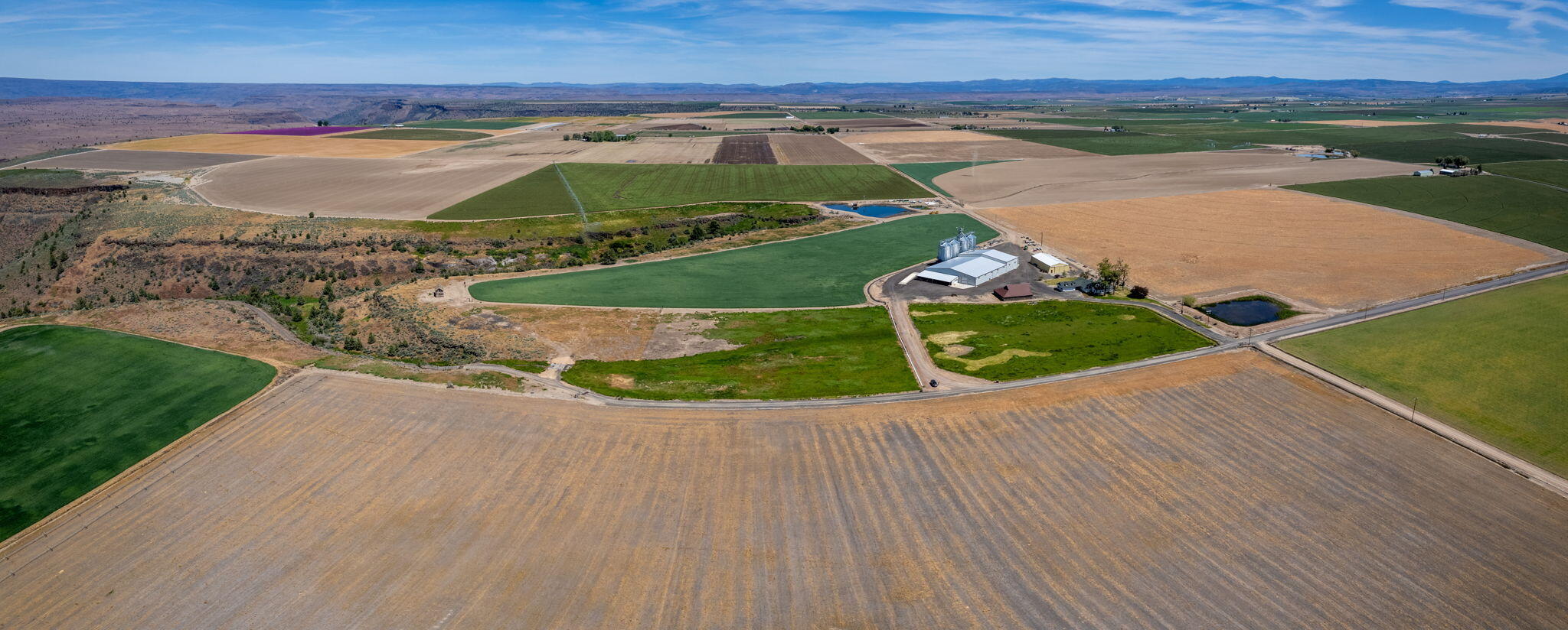 Welcome to the most breathtaking Cascade Mountain views from Madras at Agency Plains northern edge! Here you'll find the Mecca Grade: attached to BLM, the North rim that overlooks the Deschutes River Canyon and all of its splendor! Overlooking the canyon lies this unique farm property, complete with a world-class Malthouse. The 23K sf multi-purpose ag bldg (ADA accessible, heated & insulated, ODA cert. scales) that currently houses a custom-built grain processor is also fully functional as a professional sales office space with reception area, gorgeously designed conference and tasting rooms, and a well-equipped brewery. This 240 acre property with 145.5 acres of NUID water rights currently operates as a highly successful farm and distribution center and/or a destination venue for events. The on-site, stunning grain silos with conveyors total 92K bushels of storage with 2 grain cleaners and bagging line. Farmhouse has its original vintage charm, incl. updates. Opportunity awaits!