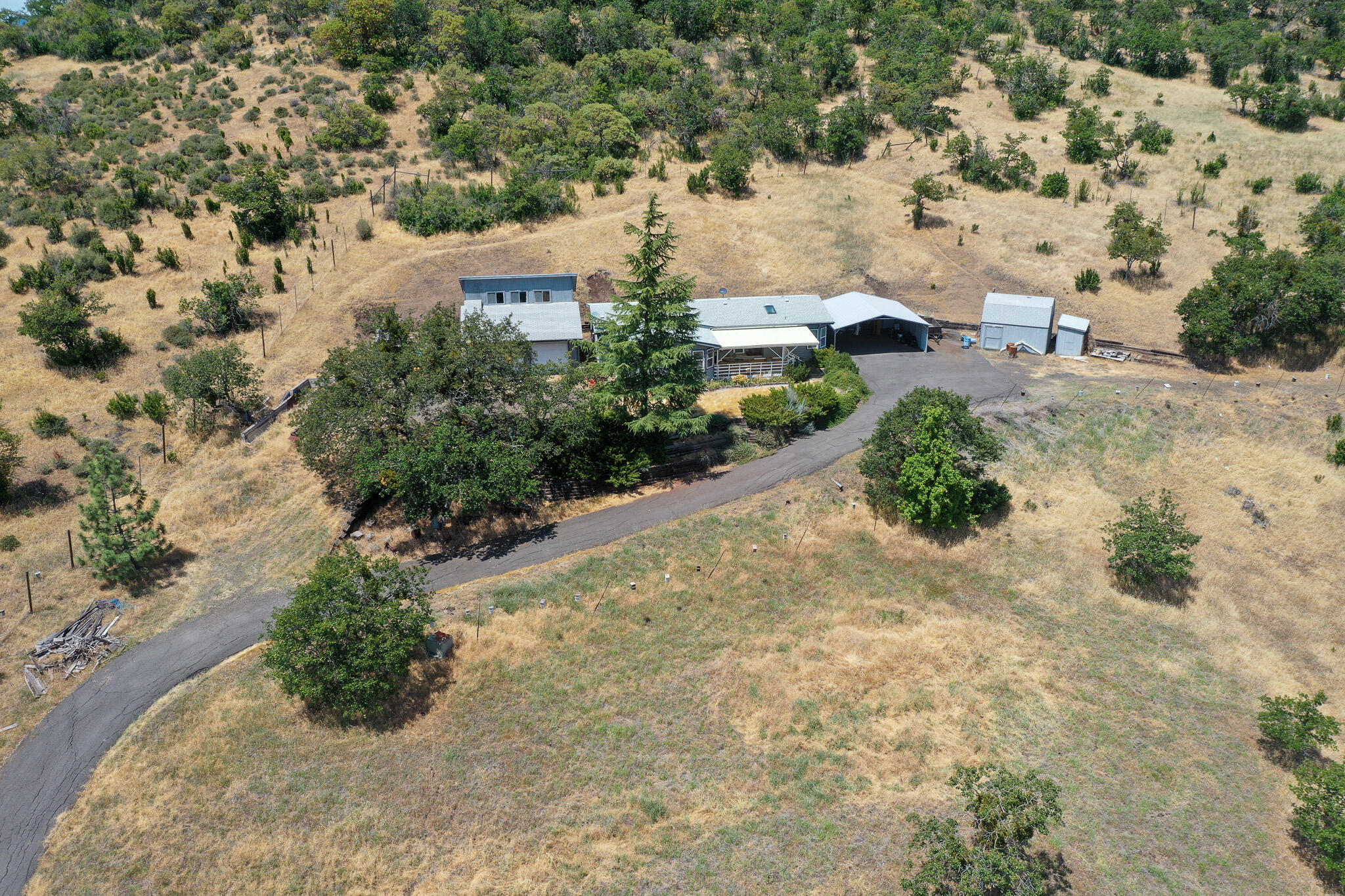 Welcome to your Eagle Point sanctuary! This charming  home sits on over 12 acres offering breathtaking mountain and valley views. Property may be able to be divided, buyer to do due diligence. Has road access to both the lower & upper ends of the property. The open-concept living and dining areas are bathed in natural light, highlighted by vaulted ceilings.  The spacious kitchen boasts lots of cabinets and a large adjacent dining area. Retreat to the tranquil primary suite with attached bathroom.

Outside, enjoy abundant outdoor living with a deck, mature landscaping, and a serene garden space ready for your creative touch. With detached 2-car garage and extra storage, this home has it all. Minutes from Eagle Point schools, parks, walking trails, and Rogue River access. A perfect blend of country charm and community convenience—don't miss your chance to make it yours!