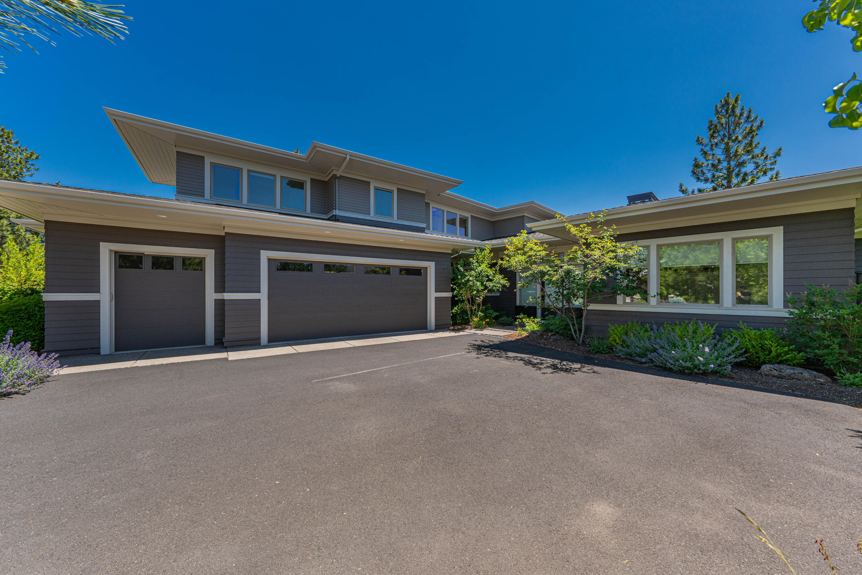 Perched on a ridge above Discovery Park, this award-winning home was the personal residence of one of the top builders in Bend. A striking glass entryway frames immediate great room views, with a wall of windows, hardwood floors, built-ins, and a rock fireplace. The designer kitchen features a large island, custom cabinetry, quartz, and top-tier appliances, opening to a dining area with banquette seating and access to spacious covered/open patios. The main-level primary suite offers lake views, a tiled shower, soaking tub, walk-in closet, and an adjacent private office. Upstairs, find two more bedrooms and a large bonus room, both with views. A 3-car garage with an epoxy floor and a mudroom with built-ins are ideal for outdoor adventures. This ridge-top home is conveniently located near Bend's best restaurants, shops, schools, parks, and trails.