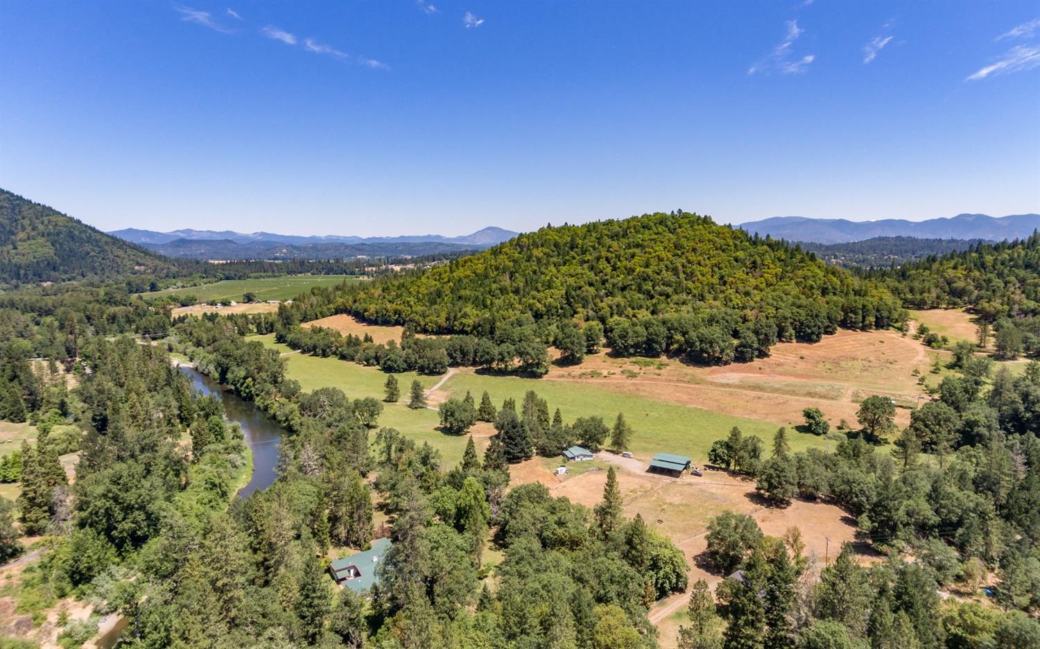 The ranch has 2,000+ ft of Applegate River frontage, 3 homes, 131 acres with 47 acres of water rights, end of the road privacy and is just a 7 mile drive from Grants Pass. There is great potential here to turn this ranch into a vineyard or riverfront development. RR5 zoning! As soon as you enter the main gate, you feel the privacy and natural beauty as you travel nearly a half mile surrounded by your own preserve to the main home on the river. The classic mid-century modern ranch home has a sprawling floor plan that w/4 beds & 4 baths. The 2nd riverfront home was completed in 2014 & features an open concept 2,686 SQFT floor plan with the master suite on the main level. This property offers great recreational opportunities for fishing (River+Bass Pond), rafting, hunting, riding, hiking and more! This property is completely fenced. The irrigation system has a 25HP pump at the river with 1.5 miles of buried mainline, w/hoses & water cannons. Completely Fenced! SEE VIRTUAL MEDIA.