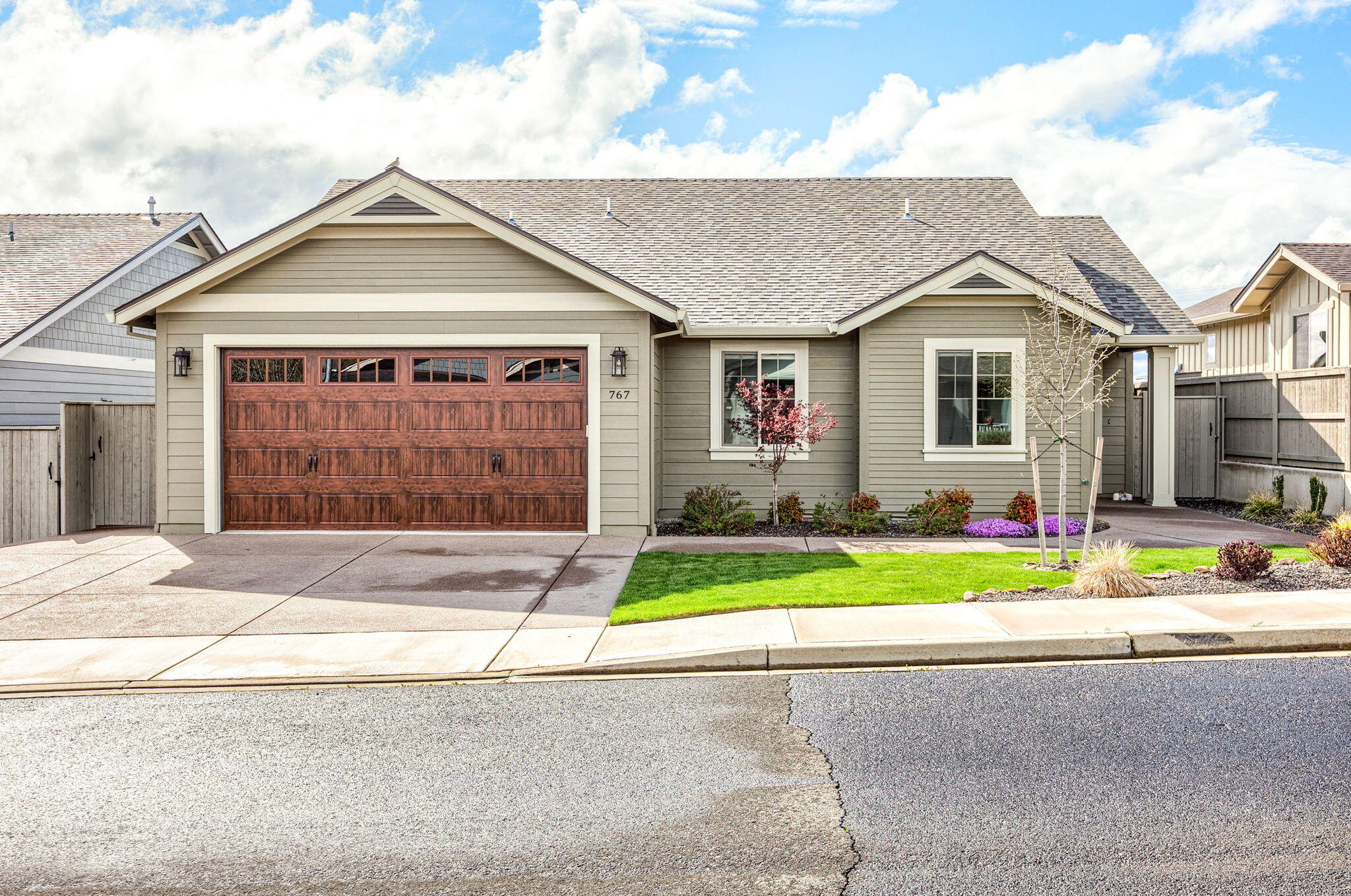 Wonderful Mahar-built, single-level home with unobstructed vineyard views in a vibrant 55+ community! This Earth Advantage Platinum home, just two years old, boasts an efficient open floor plan with high ceilings. The vaulted living room features a gas fireplace, hardwood floors, and picture windows showcasing stunning mountain views. The kitchen has stainless steel appliances, custom cabinets, and a dining area that opens to a spacious patio—perfect for indoor/outdoor living. The primary suite offers patio access, a walk-in closet, and a large en suite bath, creating a private retreat. Two additional bedrooms and a full bath provide space for guests or a home office. A laundry/mudroom leads to the two-car garage for added convenience. With quality construction, thoughtful finishes, and a peaceful setting on a quiet street, this home is a must-see!