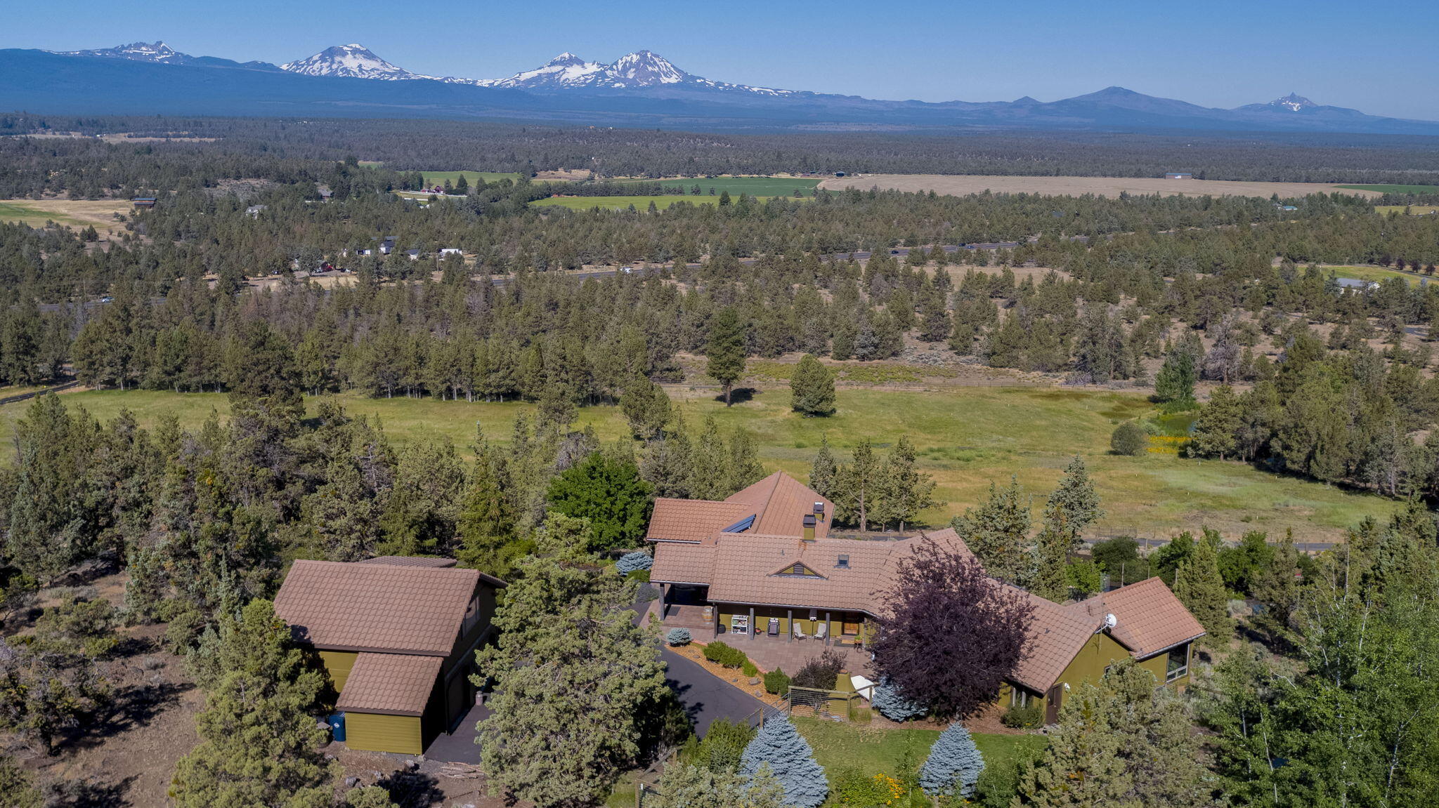 Truly Spectacular! This one of a kind Tumalo estate embodies all the warmth of SW style; exuding craftsmanship in every detail, from hand formed Saltillo tile floors to drastic wood beams supporting soaring cathedral ceilings. Nearly every room offers stunning views of the Cascade Mountains, overlooking the Tumalo valley and rolling fields and foothills. Set into the hill side it flows naturally with the landscape. Just over 21 acres, it's the perfect rural retreat. The irrigated fields, fed by two beautiful ponds, sit just below a small orchard and raised gardens. Two large barns, one with private office and bath, provide extensive storage. Above the detached garage is the perfect guest quarters, comfortable and private. Please enquire for full list of home features and to set an appointment to view in person.