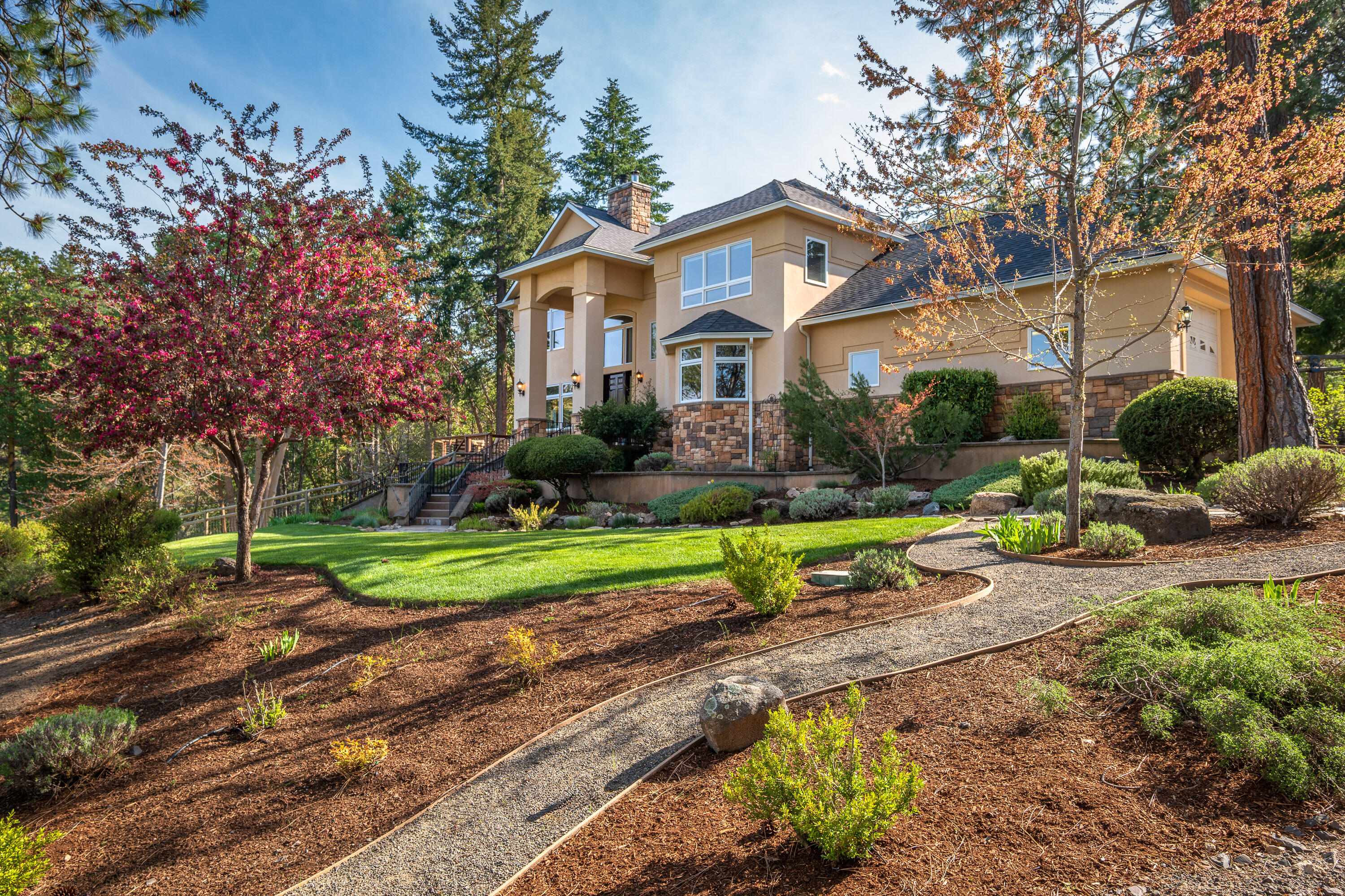 Just a short drive south of Ashland, Oregon, lies this private 22-acre retreat. This private estate features a custom home, a recently built 5,000+ sq ft shop with striking modern design, plus sweeping views of the mountains. Inside, the home welcomes you with a bright entry foyer, cathedral ceilings, and a Tulikivi soapstone stove. The modern kitchen is equipped with high-end appliances and flows seamlessly into the dining room and living area. The main level also includes a spacious guest bedroom, full bath, walk-in pantry, and utility room w/half bath. Upstairs, the primary suite offers a walk-in closet and luxurious private bath, accompanied by two additional bedrooms, a guest bath, and a 2nd laundry room. The shop includes flexible space for vehicles, hobbies, a gym, or workshop. Outdoors, enjoy 900 feet of Slide Creek, hike through the well-maintained forest, or unwind in the hot tub. This is a rare blend of seclusion, usable land, recreation, and convenience.