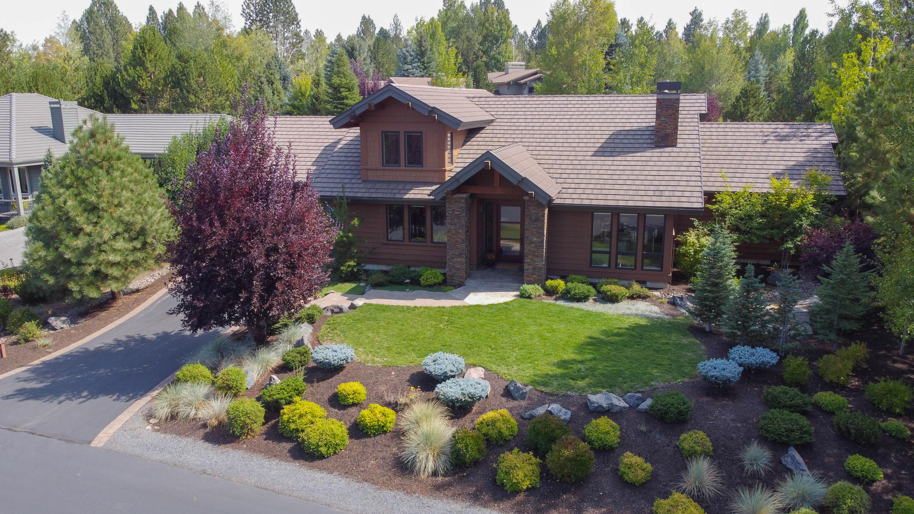 Experience this stunning home where Pacific Northwest architecture and contemporary design converge with natural surroundings just out the front door. Discover a 4-bed, 3.5-bath haven at Broken Top Community. Great room floorplan with large view windows, floor to ceiling stacked stone gas fireplace with custom wood mantle, hearth, and built-ins, vaulted ceiling, and Acacia hardwood flooring. Slab granite kitchen island with extra seating, counters with subway tile back splash, stainless appliances, and remote Hunter Douglas blinds. Thoughtful separation to the primary suite wing with spa like tile walk-in shower. Two bedrooms on the main with another bedroom, full bath, and media/ bonus room upstairs. Easy access to miles of soft trails. Enjoy the spacious grassy level above the covered outdoor living area with stamped concrete patio and hot tub. Naturally landscaped with some lawn. The heated garage is a 3-car tandem with custom built-ins. Visit: BrokenTop.com