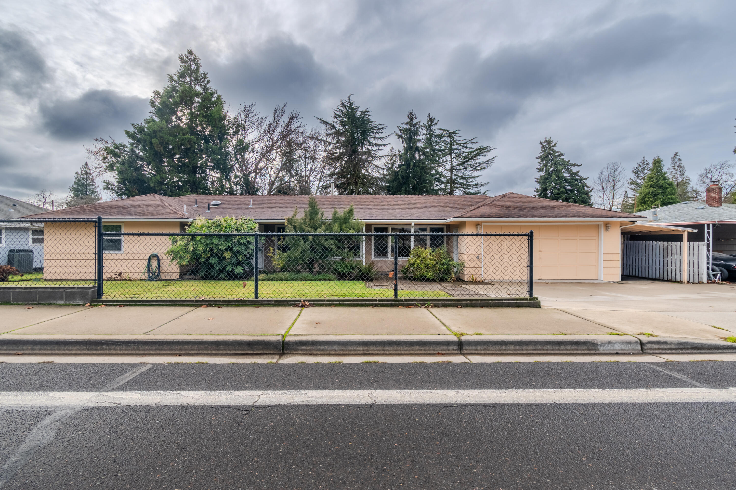 East Medford home with 4 bedrooms, 2.5 baths, large bonus room all  on a large .32 acre lot. Open living and dining areas with beautiful hardwood floors, fireplace w/insert and 2 large picture windows. Remodeled kitchen, cabinets with pullouts & lazy susan, tile floor, Corian counter tops and a built-in desk. Large bonus room with tile flooring overlooks the backyard and has French doors that lead to the covered patio, great for summertime entertaining. Spacious laundry room with large closet. Master with laminate flooring, double vanity, separate  toilet/shower area. Hall bath with tile shower and floor and has a door to the bonus room. Half bath with tile floor and newer vanity.  Large fenced backyard with covered patio, small pond with waterfall feature and  plenty of room for a garden. 2 car garage plus a covered carport parking area.