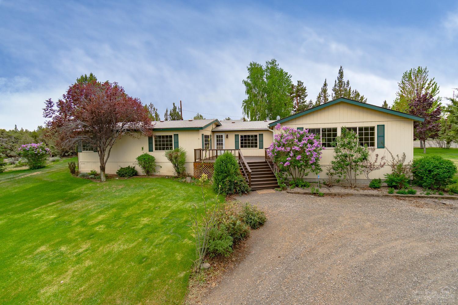 Must see property on south edge of Eagle Crest. Enjoy an extremely private & serene setting w/a sprawling lawn & ready to go garden. 2628 sf home w/stick built addition offers space to entertain year round, extending to the covered deck & front sun deck. Kitchen w/plenty of counter space, additional Buffet & formal dining. Master Ste w/soaking tub & walk in shower. Multiple living spaces to accommodate a lg family or gathering. Over sized, extra deep dbl garage w/built ins & Office/bonus area & a cold storage room. Shop has full sized doors for RV storage, 220 power & slab floor. Complete RV hookups w/turnaround, additional single garage & additional storage buildings! Property is gated & fully fenced. Terrain views clear to Smith Rock!