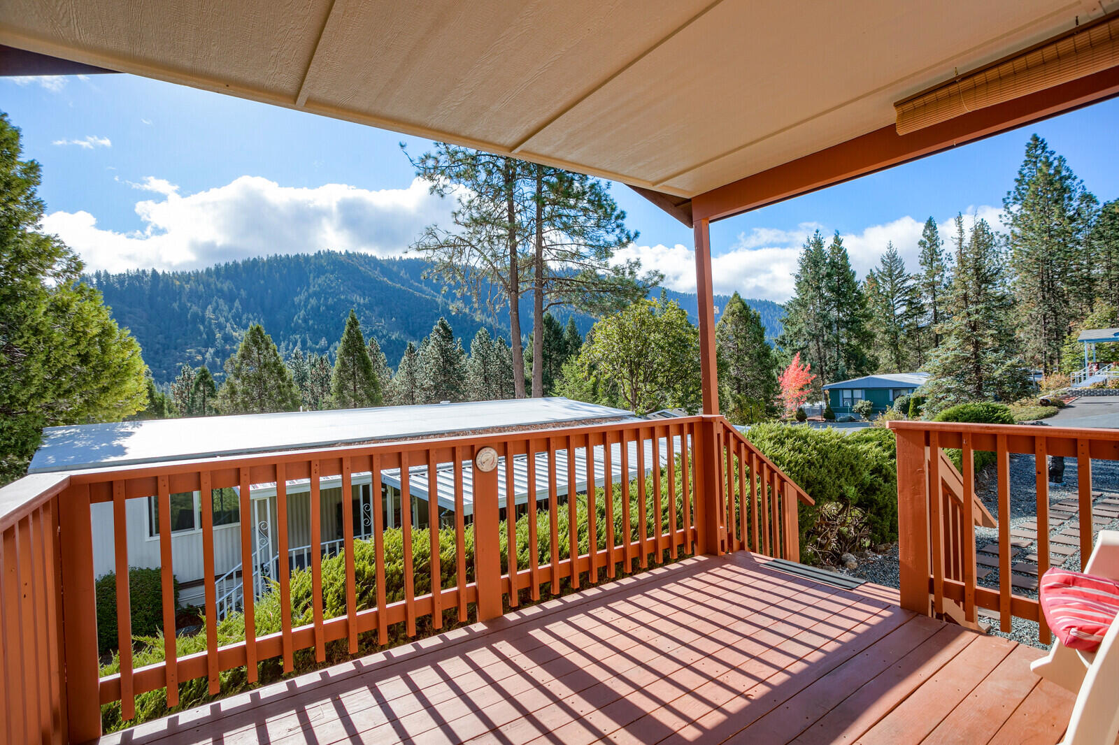 Experience the forested landscape and majestic mountain views of Rogue River Mobile Estates 55+ park. Nestled near the quaint town of Rogue River, location is key with this home being tucked away in the rear of the park, and this space number backs to BLM land. With easy care landscape, and a front deck to enjoy your morning coffee. You'll have plenty of room to cook in this spacious kitchen that is open to the living room & dining room. The split floor plan creates privacy with the main bedroom being on the opposite side of the house from the other two bedrooms. Main bedroom has its own roomy private bathroom and large walk-in closet. This home is clean and move-in ready! There is plenty of parking with an extra-large, detached carport, as well as a garden shed for storage. Come tour this lovely home and make it your own!