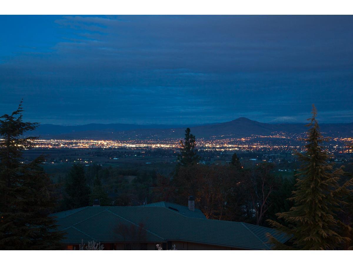 Jacksonville's Coachman Hills elegant home! Extraordinary views of Mt. McLoughlin, Crater Rim, Table Rocks and the Rogue Valley! Entering into an architectural delight that boast superior craftsmanship. Gorgeous gourmet kitchen opens to family room, fireplace and large deck. Dining room is adaptable for large and small groups. Capture the essence of views and private balconies from two Private Master Suites with one ADA bathroom. Seek out the private office/den to keep you cozy near the fireplace. Great laundry room off the three car attached garage. The Lower level features a family room, wet bar, three bedrooms and two bathrooms. Upper level gives you two separate storage areas, hall bath, open loft space, private bedroom or hide-a-way office. A bonus room could be a screening room. Want more? Escape outside to your private finished workshop already plumbed for toilet and shower. Use the doorway to enter or garage doors. Natural Landscaping Speaks Jacksonville!